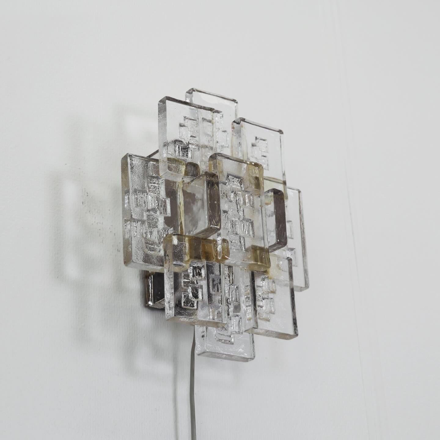 Exquisite Glass Sconce designed by Svend Aage Holm Sørensen in the 1960s

* Heavy wall lamp with thick textured transparent glass bricks 
* Designer: Svend Aage Holm Sorensen
* Model: 5175
* Producer: Holm Sorensen & Co. 
* Country: Denmark
* Year: