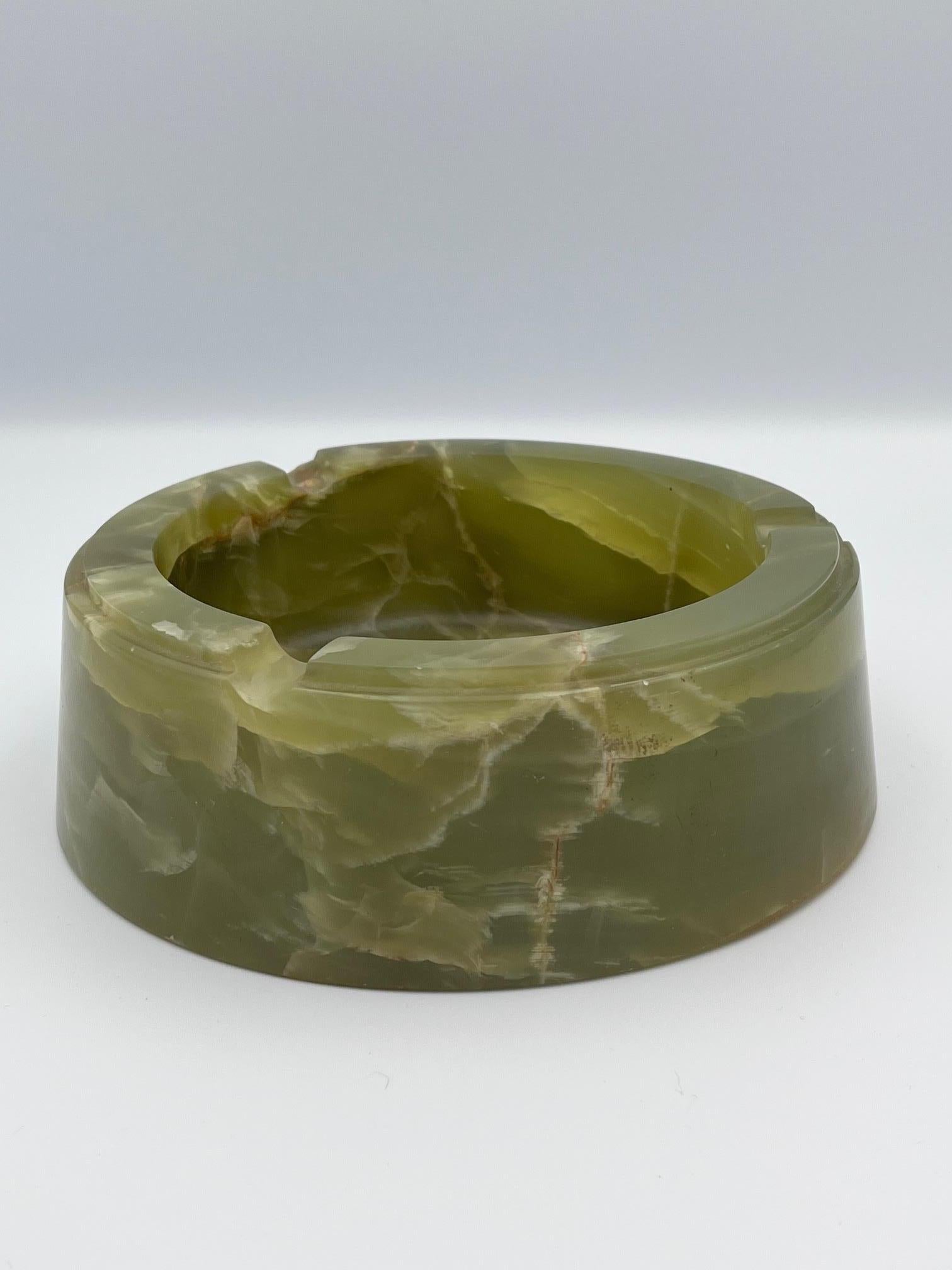 Dieser massive und schwere Zigarren-Aschenbecher aus grünem Onyx ist ein beeindruckendes Beispiel für Art-Déco-Raucherzubehör und verkörpert die Eleganz und Handwerkskunst des frühen 20. Dieser runde Aschenbecher ist aus echtem grünem Onyx