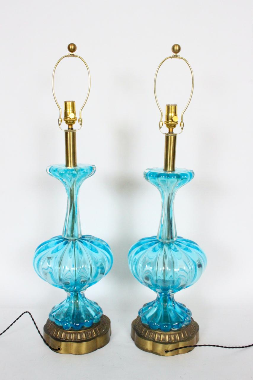 Tall Pair of Italian Mid Century Translucent Turquoise Murano glass table lamps. Featuring hand blown smooth ribbed Aqua Venetian Murano bulbous glass forms with upper and lower scalloped fluting, Brass necks, atop decorated round (8D x 2.75H)