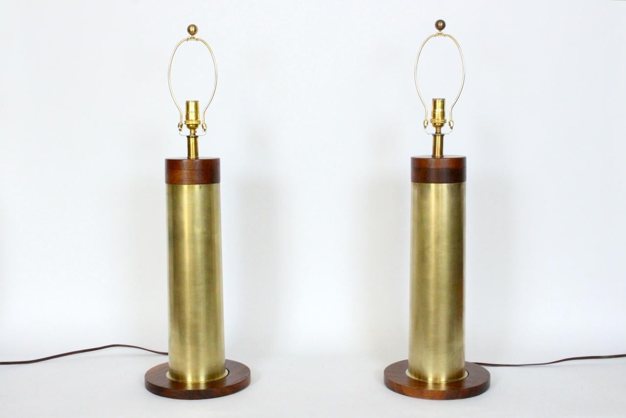 Tall Walter Von Nessen style brushed brass and stacked walnut table lamps.
Featuring cylindrical 5D Brass columns capped with stacked Walnut atop balanced Walnut bases. Small footprint. 26.5H to top of socket. Brass 21.5H. Refinished. Shades shown