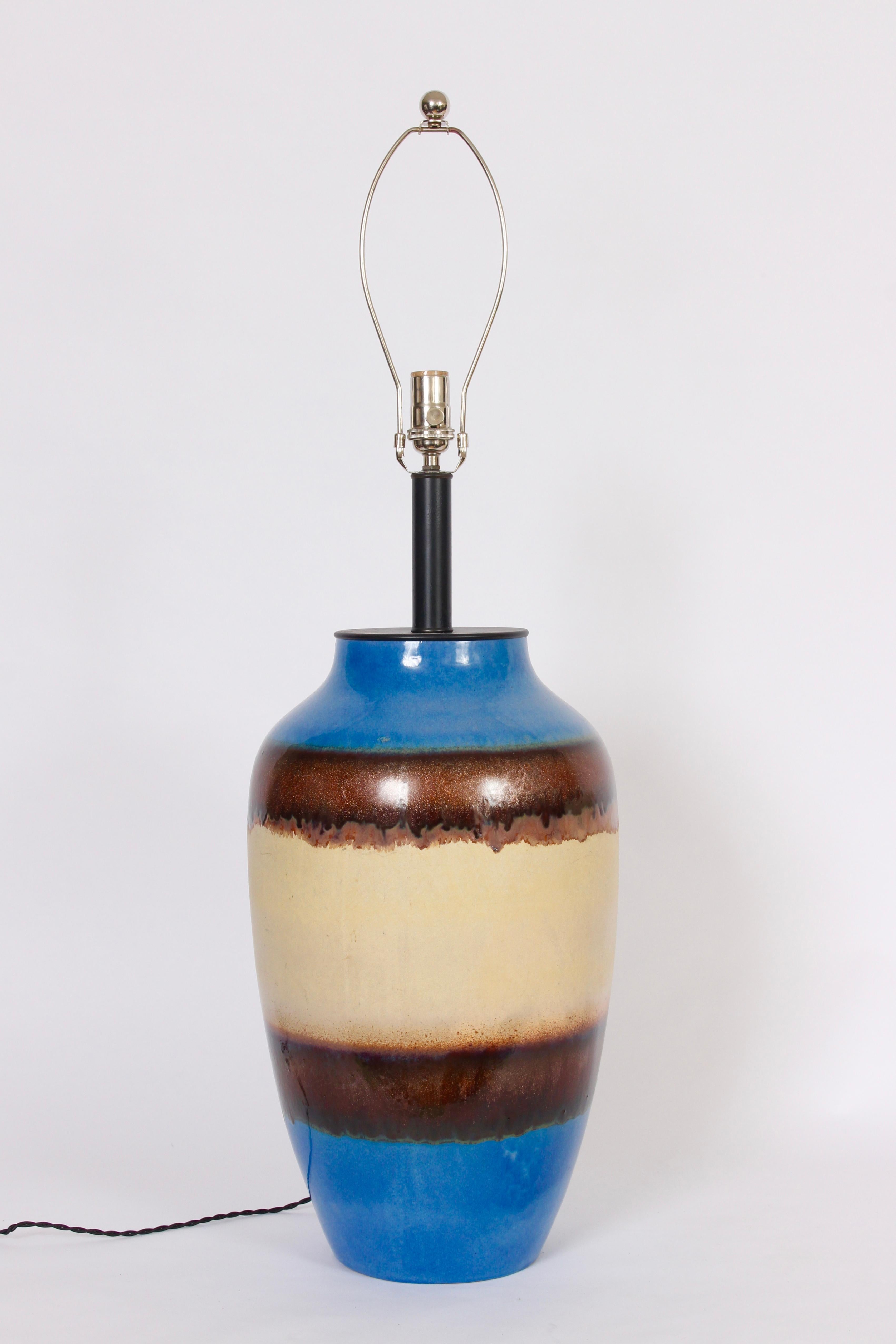 Monumental Raymor, three foot high, blue, copper and cream ceramic table lamp, from the 1960s. Featuring a large oil jar form handcrafted with reflective horizontal drip glaze in blue, beige, copper and rust. Black neck and cap. Shade shown for