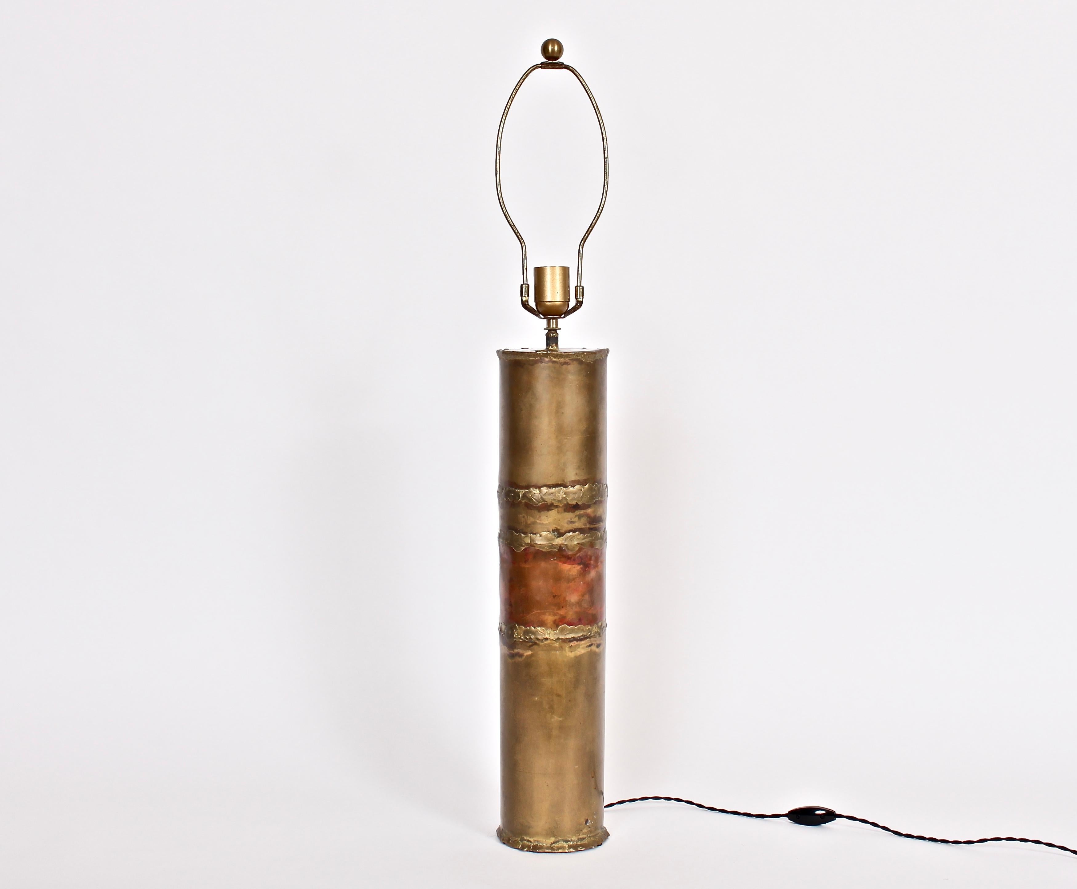 Tall handcrafted torch cut and welded brass and copper table lamp. Featuring a studio made cylindrical form, hand worked in Mixed Metal. With Cord switch. Shade shown for display only (15 H x 13 D top x 15 D bottom). 24 H to top of socket. Top of