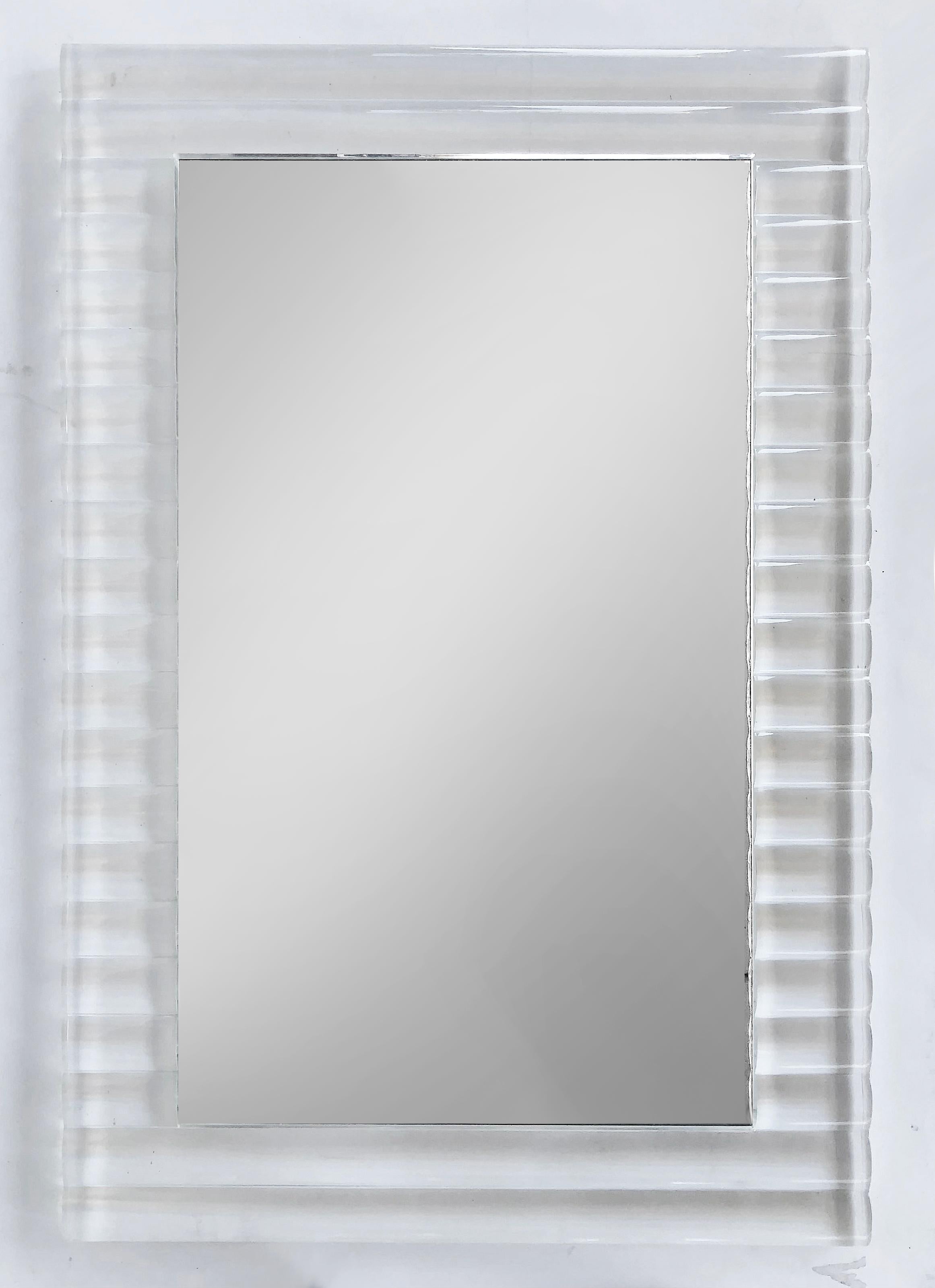 Substantial Vintage Lucite Framed Ribbed Wall Mirror, Signed

Offered for sale is a heavy-gauge ribbed pattern lucite wall mirror That is circa 1980. This heavy mirror is illegibly signed within the top right-hand border. The mirror hangs on the