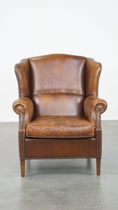 Subtle and comfortable cognac-colored sheepskin wing chair in English style