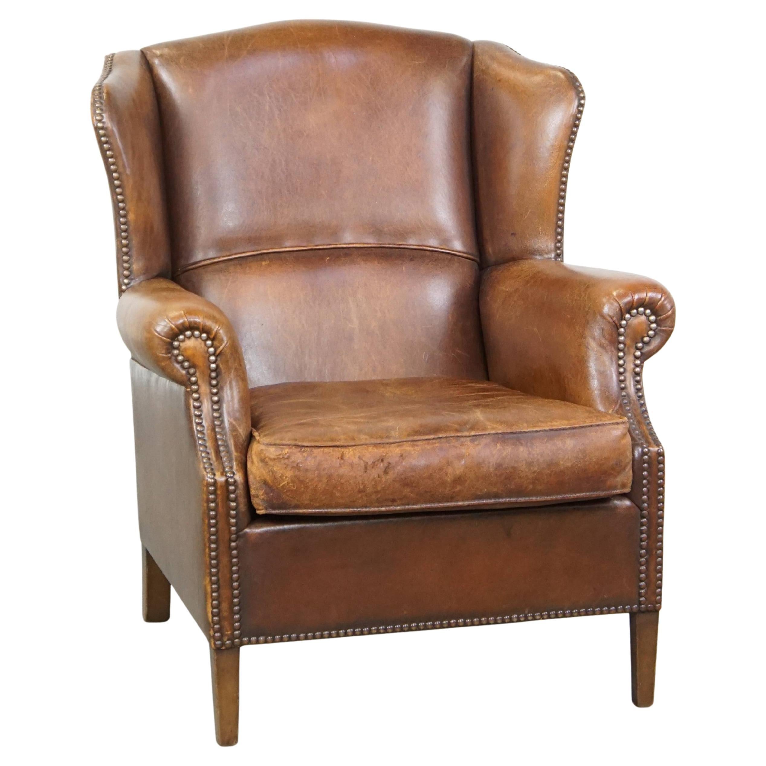Subtle and comfortable cognac-colored sheepskin wing chair in English style