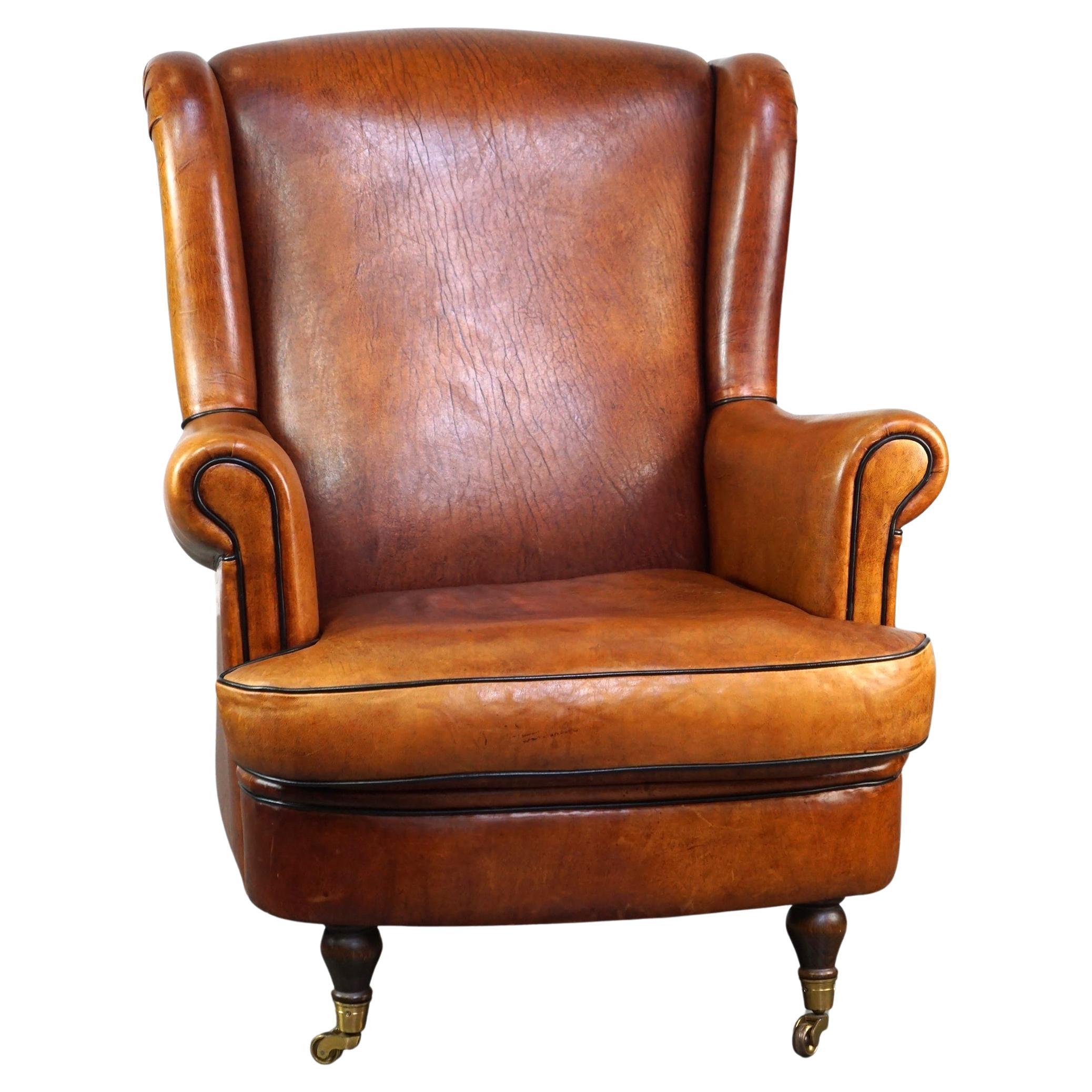 Subtle and well-maintained sheep leather armchair on brass front wheels