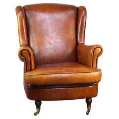 Subtle and well-maintained sheep leather armchair on brass front wheels