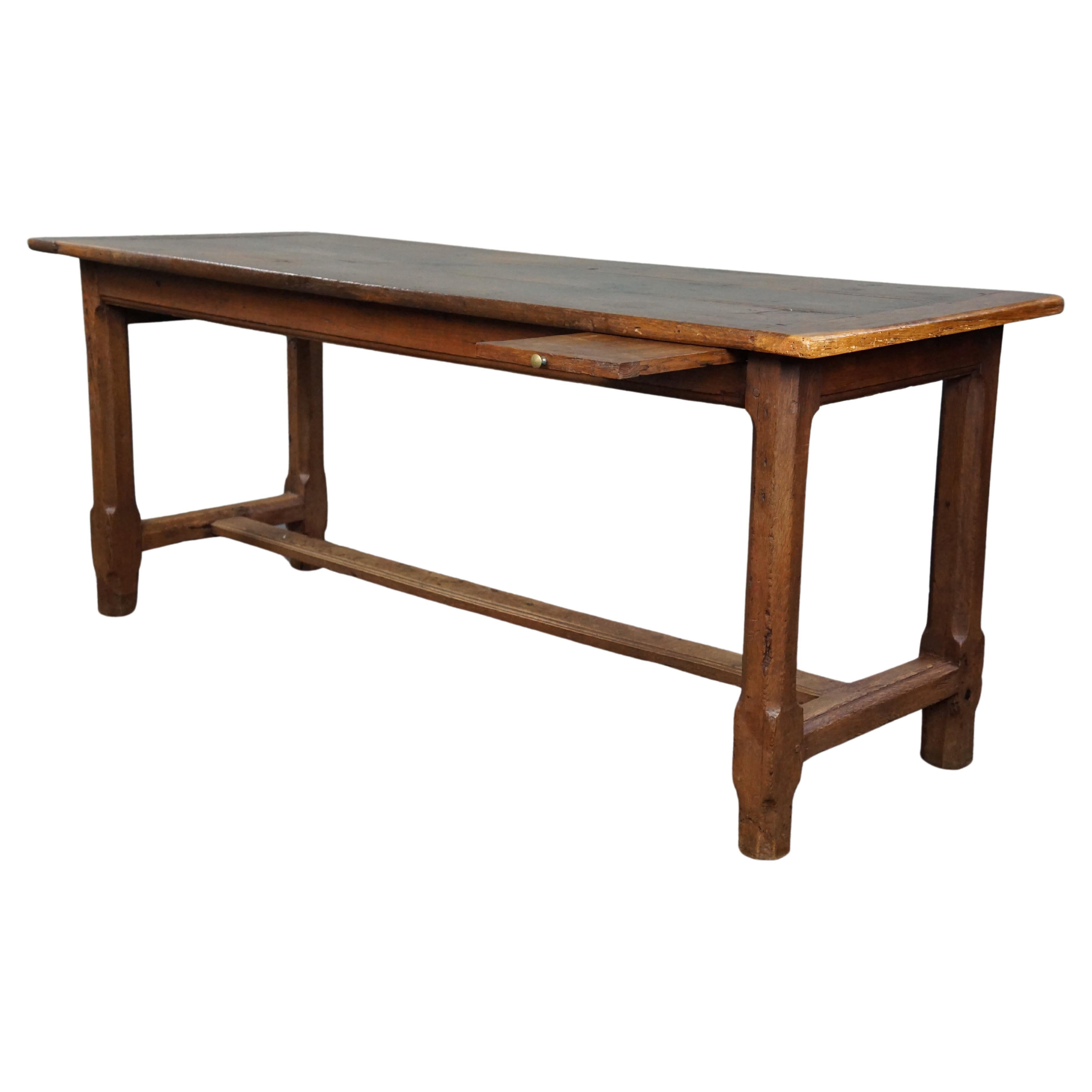 Subtle antique French oak dining table with breadboard and drawer For Sale