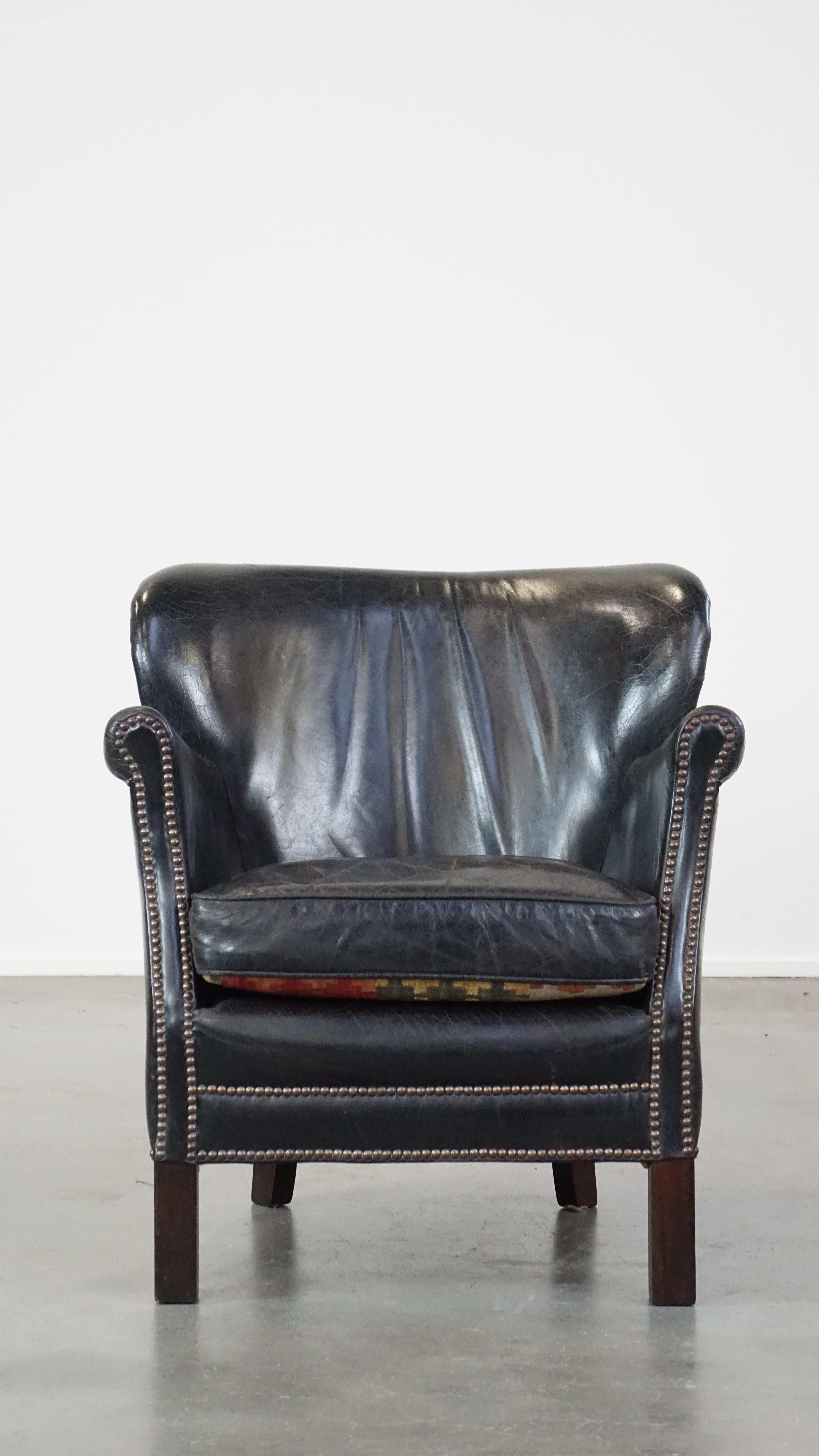 This lovely leather armchair, despite its modest size, is comfortable to sit on. It has a beautiful deep color and naturally features a lovely lived-in/patina look. It comes with a loose seat cushion that can be used on both sides. Structurally, it