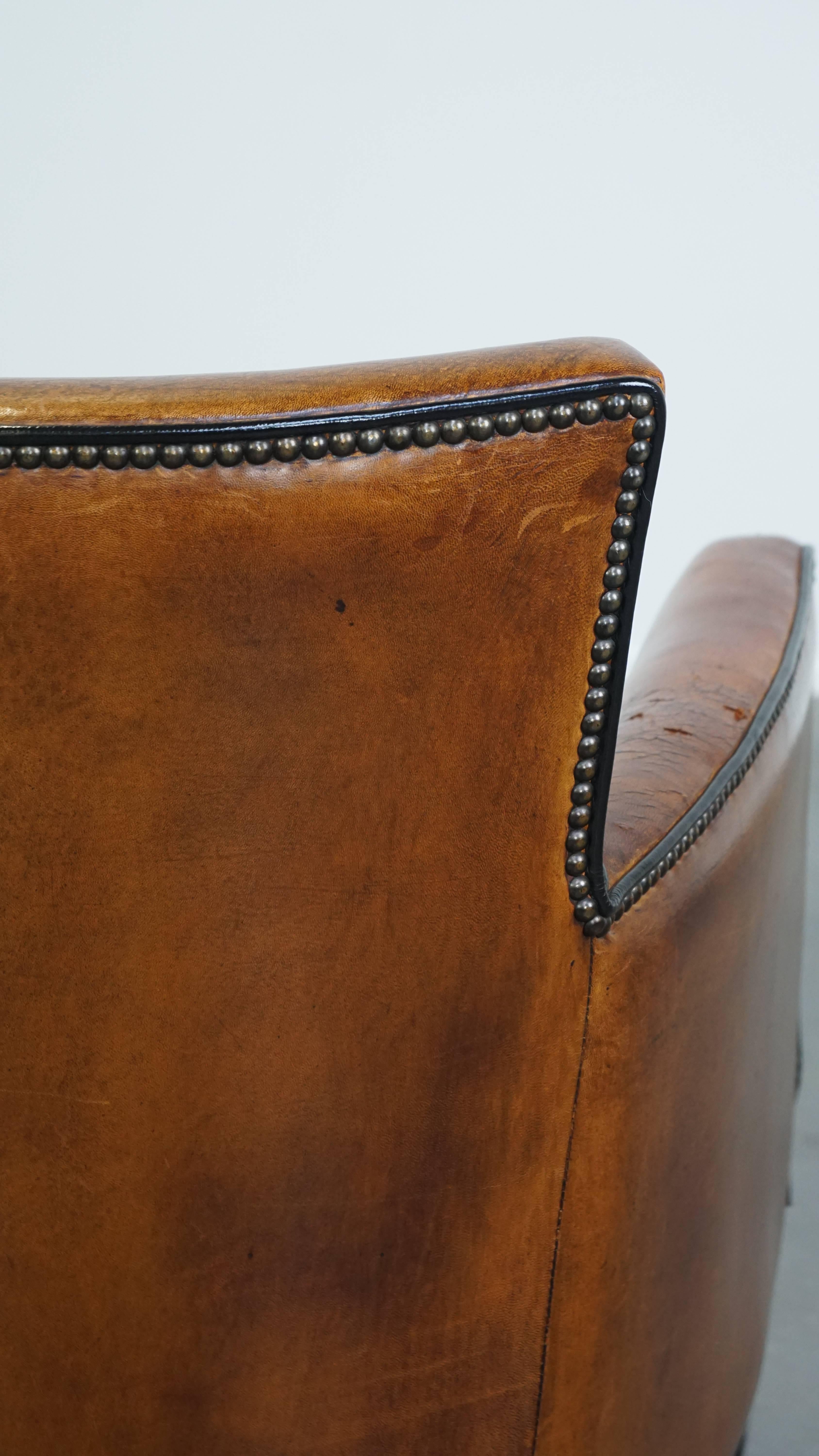 Poltrona in pelle di pecora color cognac con profili neri e chiodi decorativi in vendita 4