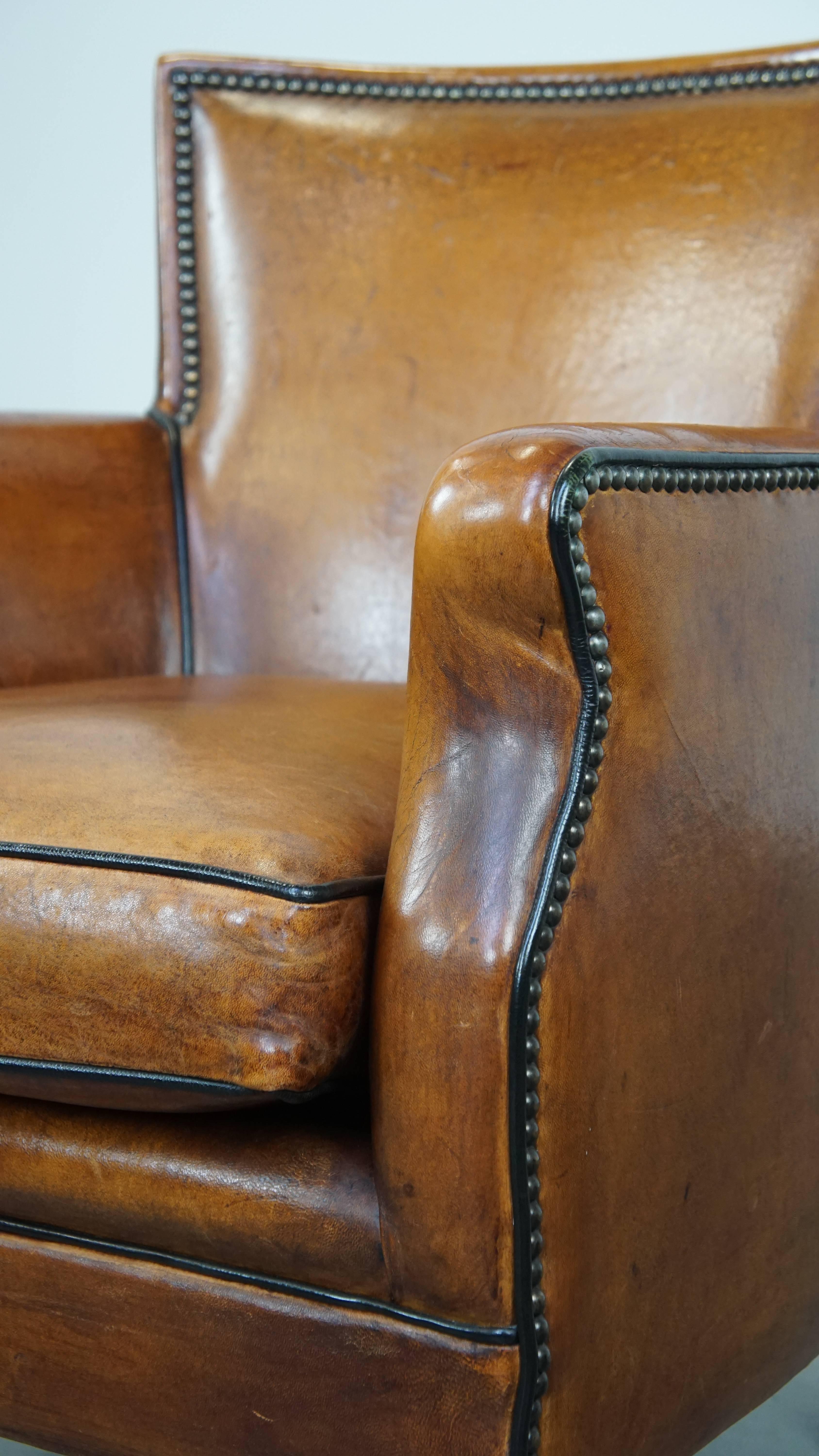 Poltrona in pelle di pecora color cognac con profili neri e chiodi decorativi in vendita 5