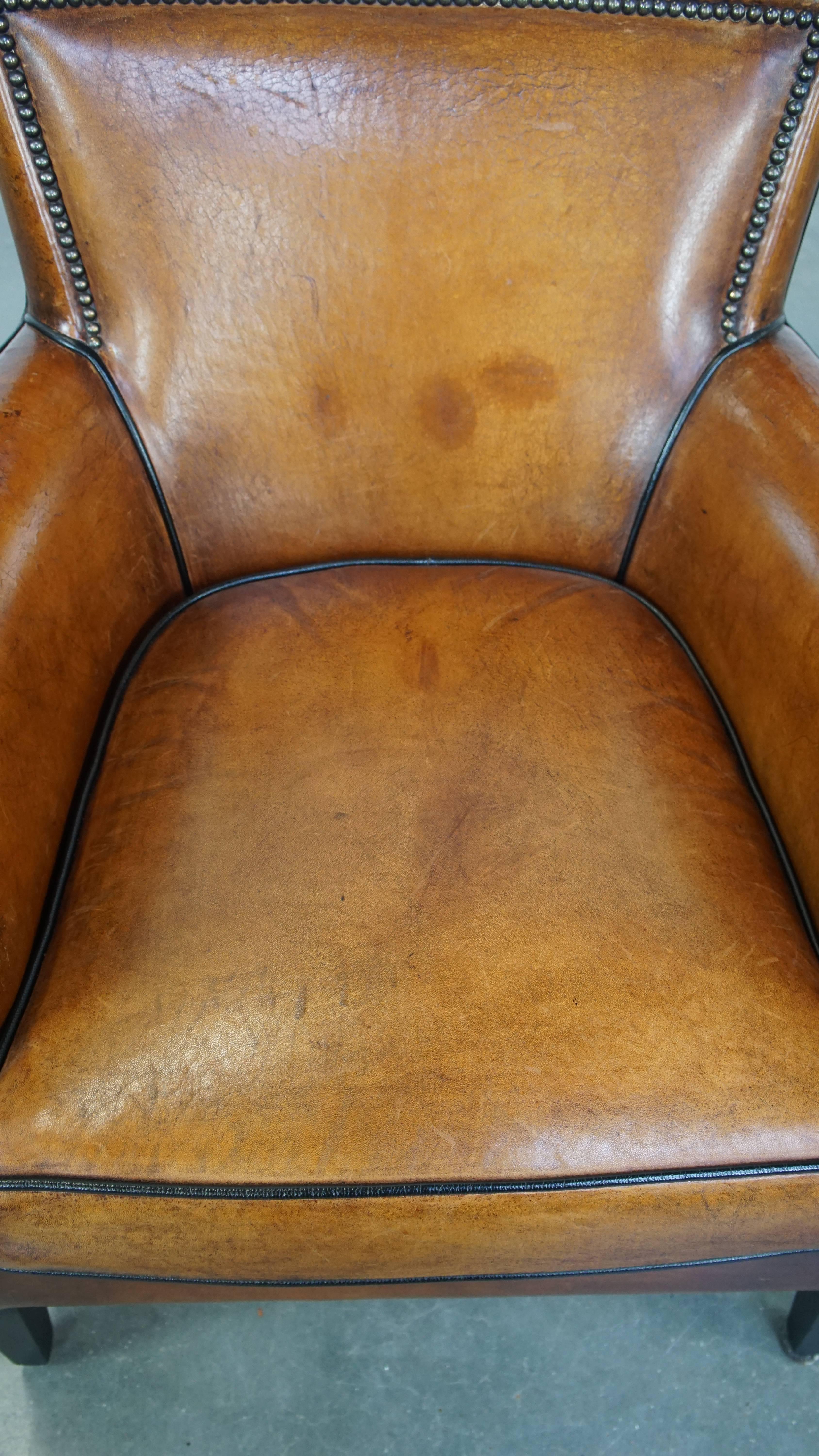 Montone Poltrona in pelle di pecora color cognac con profili neri e chiodi decorativi in vendita