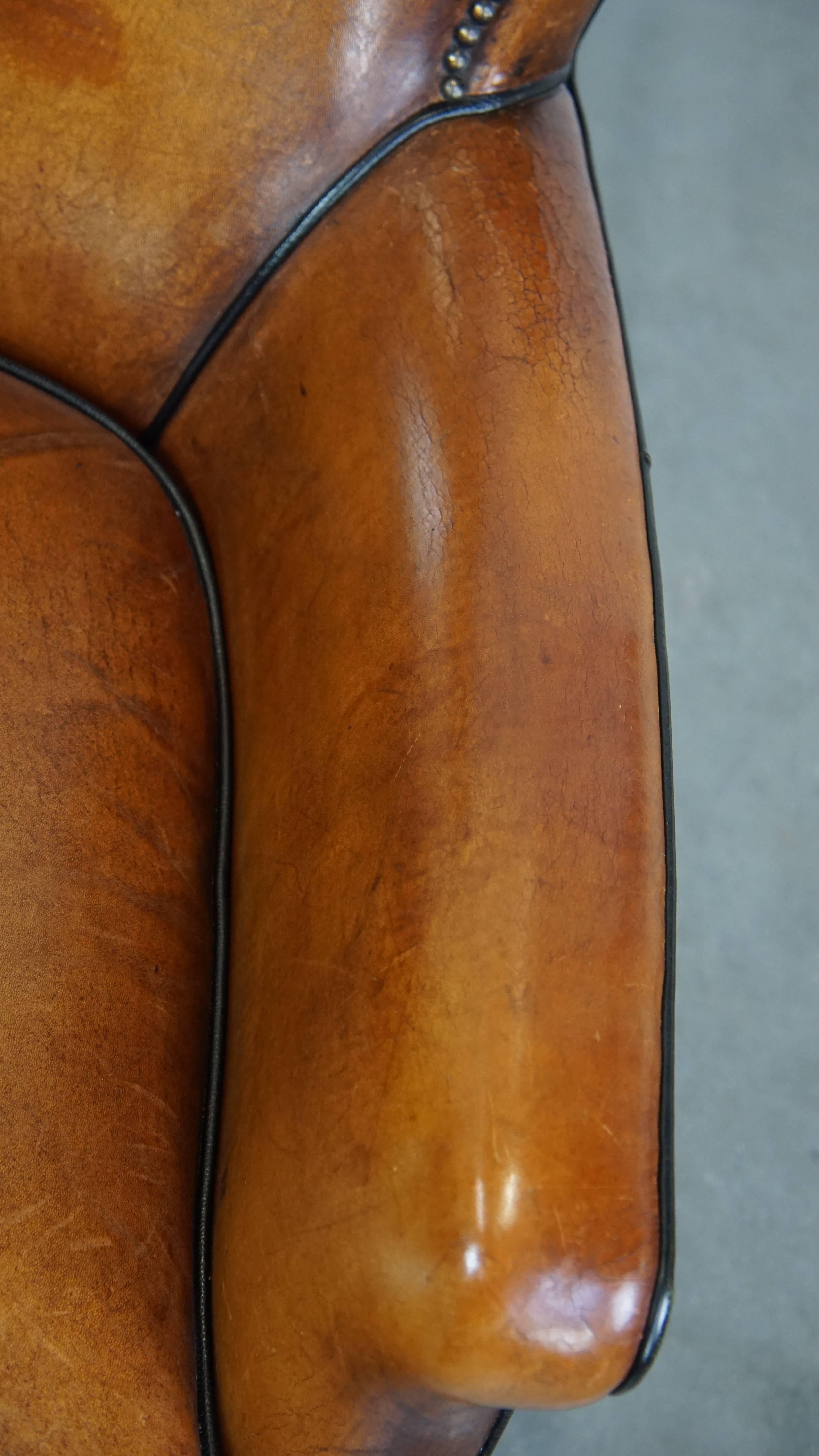 Poltrona in pelle di pecora color cognac con profili neri e chiodi decorativi in vendita 2