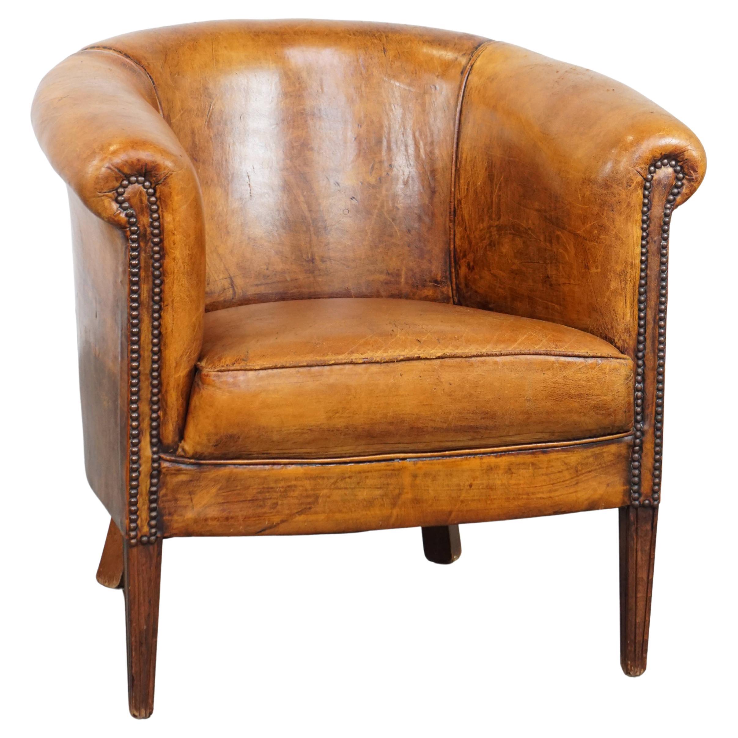 Subtle, cognac-colored sheepskin leather club chair with a timeless design