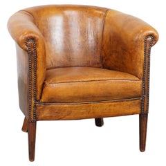 Subtle, cognac-colored sheepskin leather club chair with a timeless design