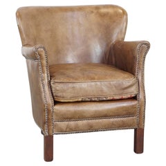 Subtle leather armchair with a reversible kilim seat cushion