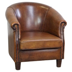 Subtle, neat sheepskin leather club armchair with a fixed seat cushion