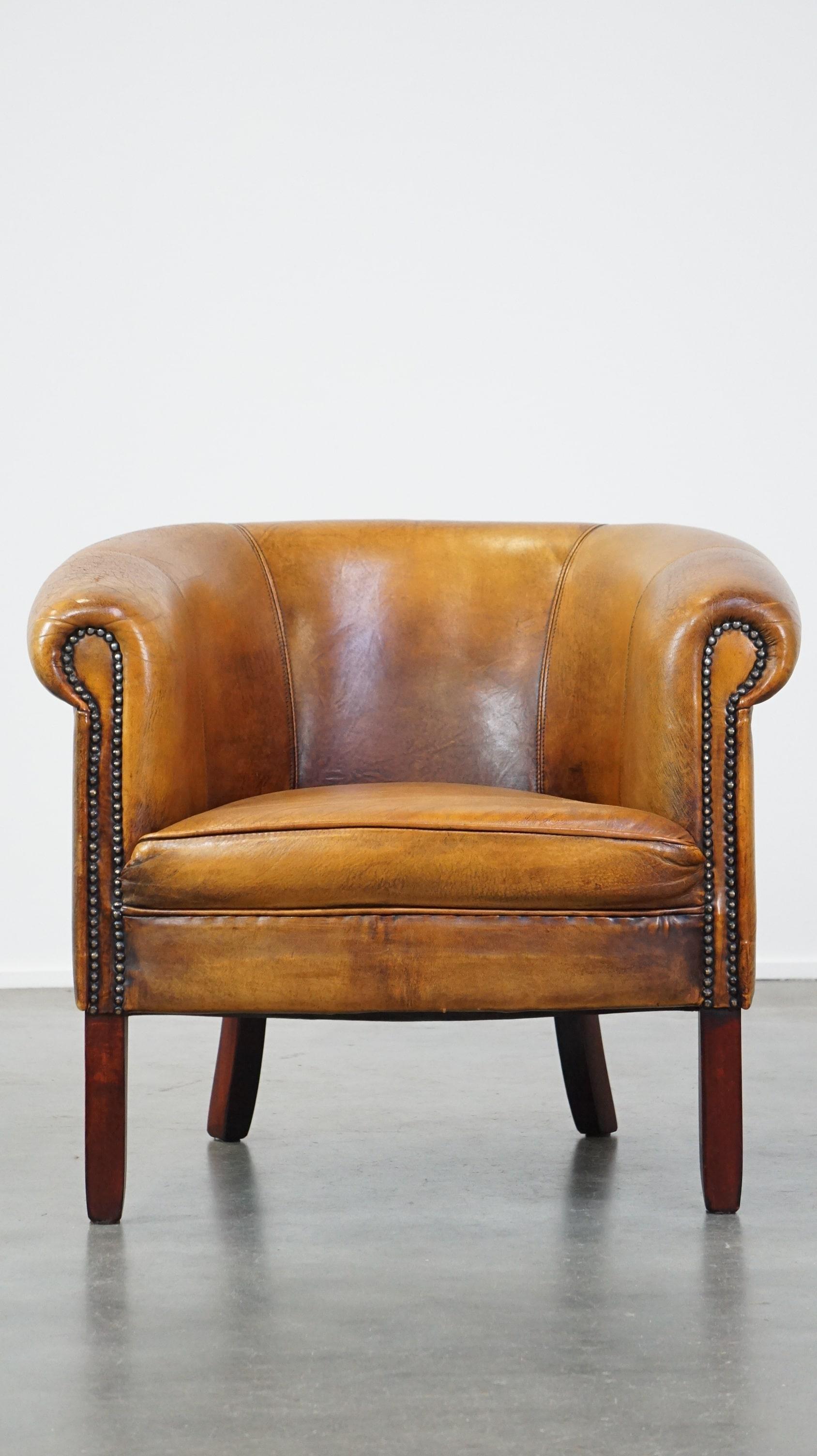Este sutil sillón club, hecho de piel de oveja, encaja perfectamente en casi cualquier interior. El sillón club está acabado con tachuelas decorativas y tiene un aspecto tranquilo. Está equipado con un cojín de asiento fijo y ofrece una buena