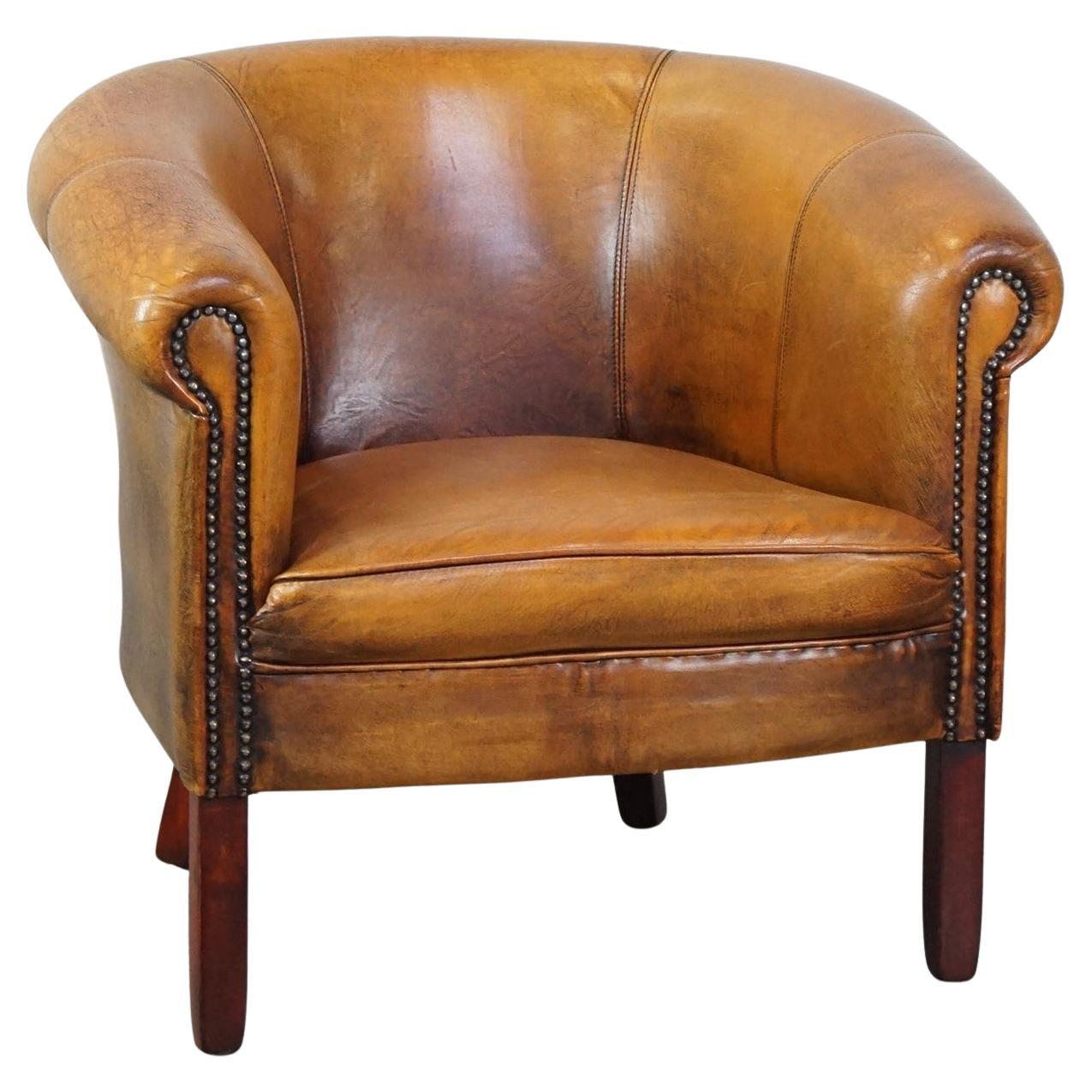 Sutil sillón club de piel de oveja acabado con tachuelas decorativas y bellos colores en venta