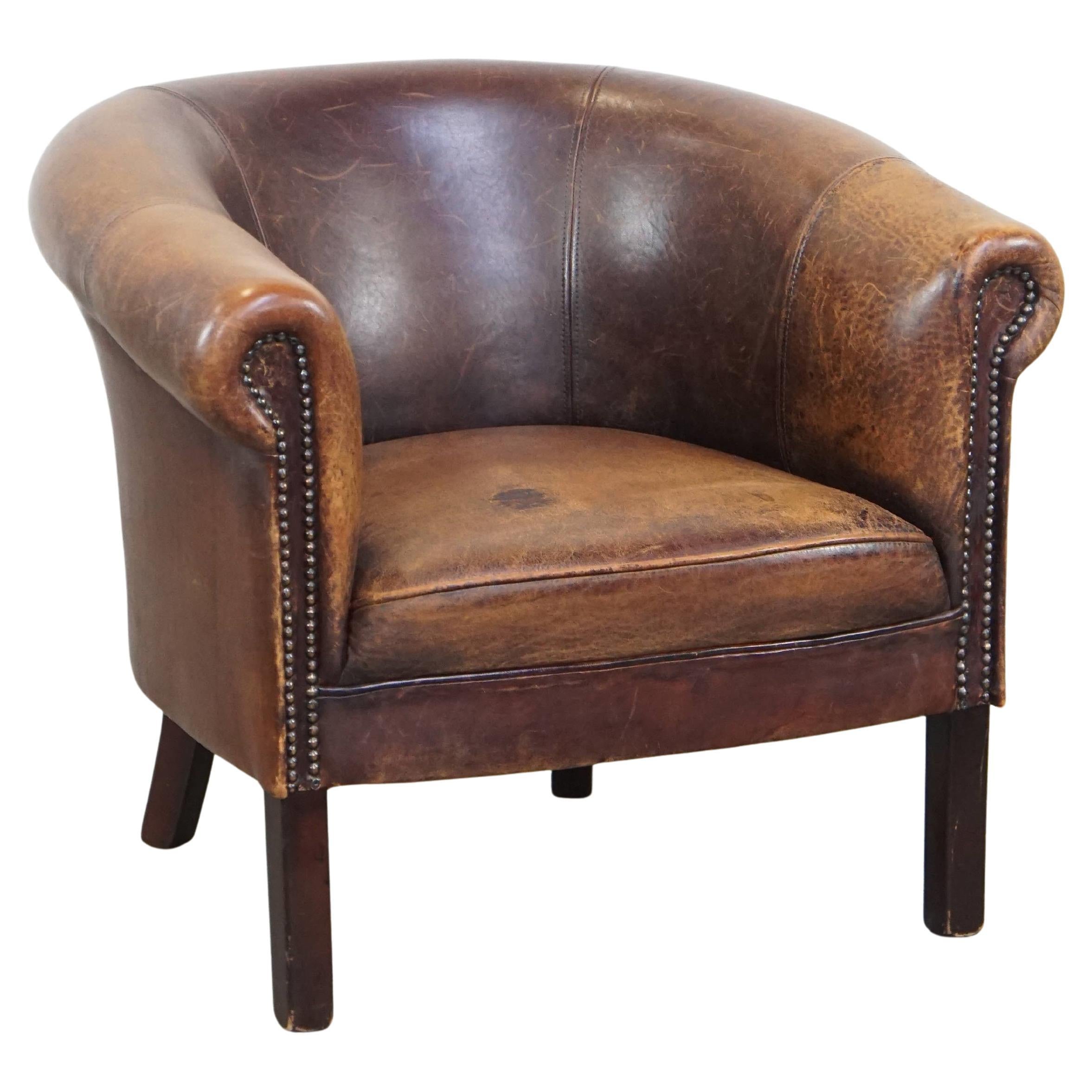 Sutil sillón club de piel de oveja de aspecto robusto