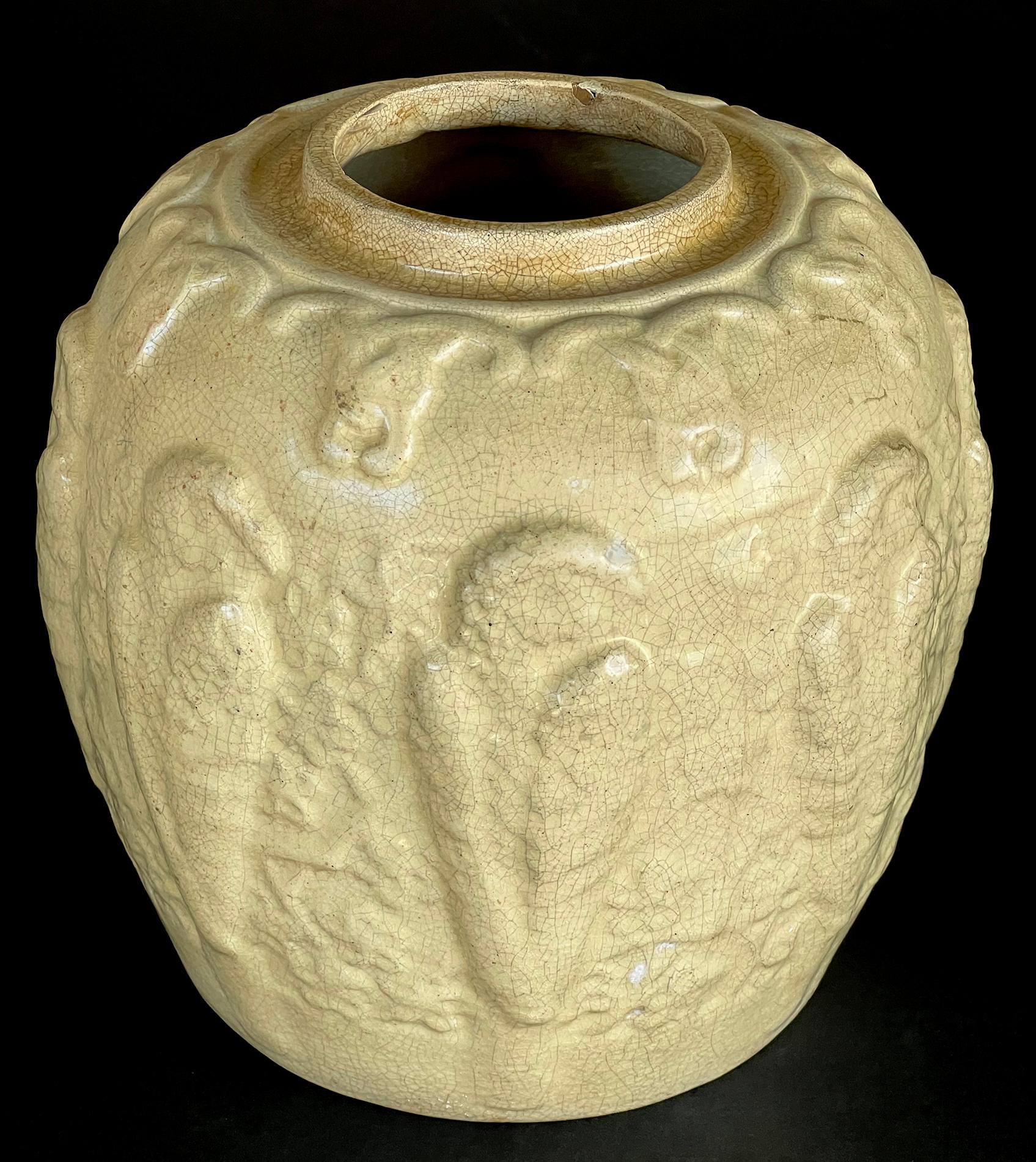 the ovoid pot with short neck above a tapering body adorned with carved relief decoration depicting parrots