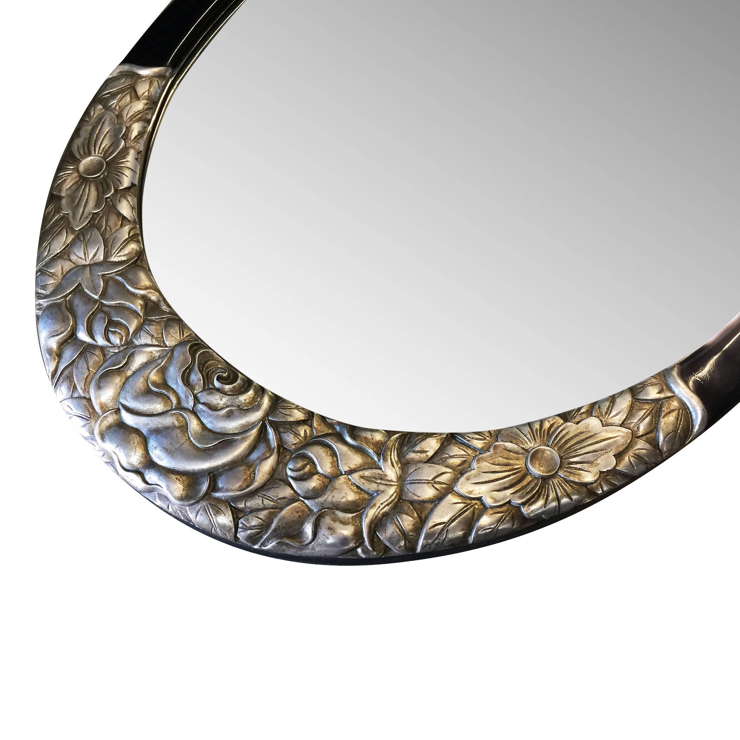 This large oval mirror in the style of Sue (Louis Sue 1875-1968) et Mare (Andre Mare 1887-1932) has a beautiful elaborately hand carved frame of giltwood on upper and lower sections. Upper section includes gilded floral carvings that extend to