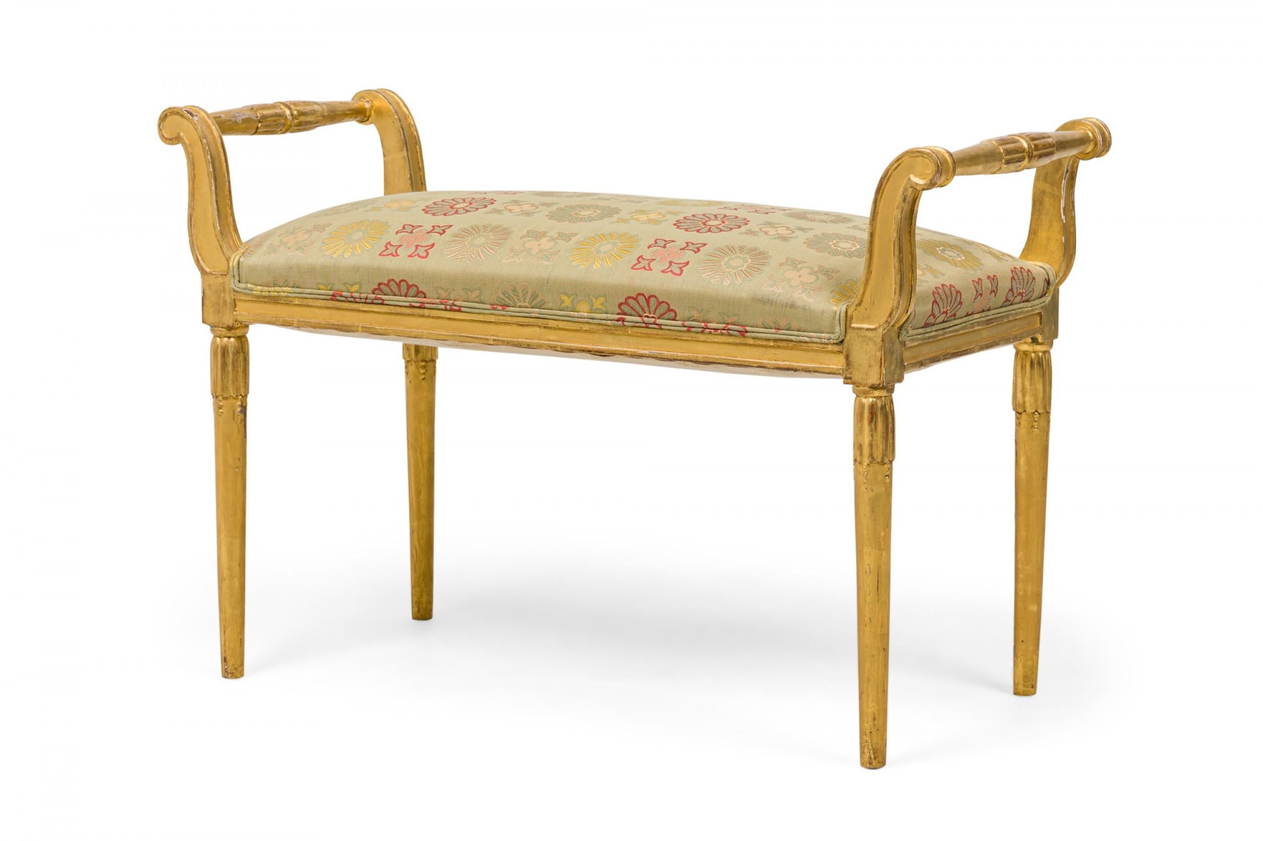 Französische rechteckige Bank aus vergoldetem Holz im Art Déco-Stil (frühes 20. Jahrhundert) mit nach außen ausgestellten Griffen in Form einer Schnecke und geschnitzten, kannelierten Verzierungen. Die Sitzfläche ist gepolstert und mit einem blass