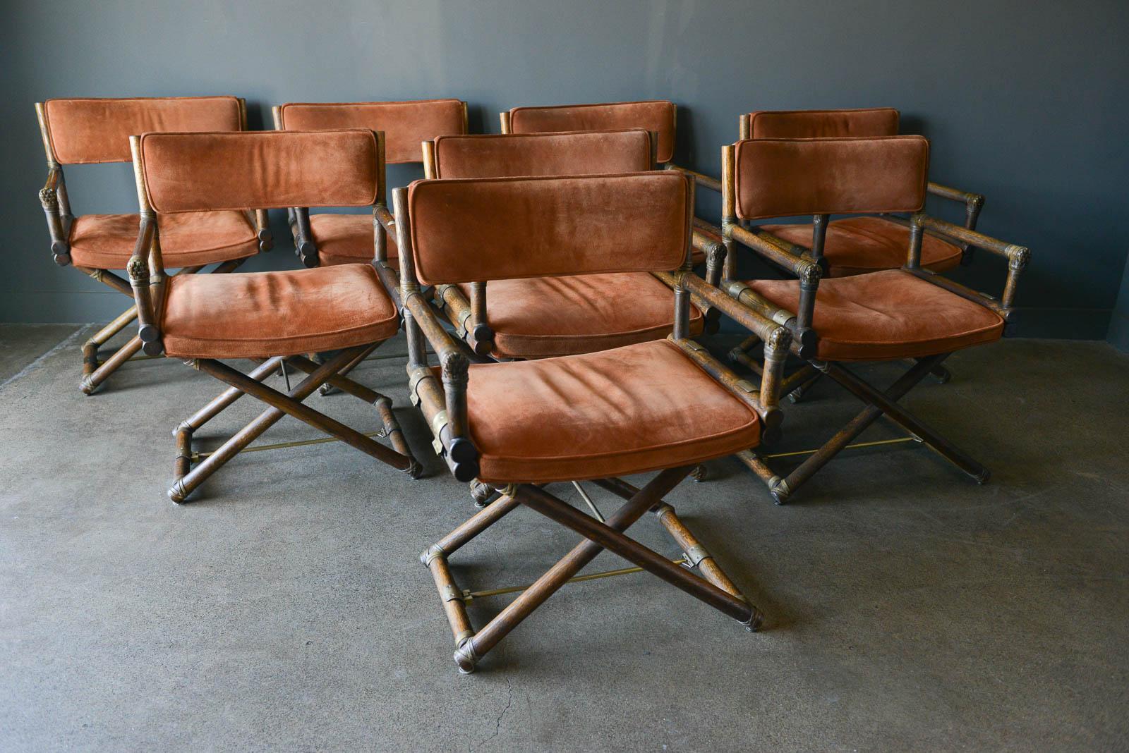 Set of 8 suede and oak directors chairs by Lyda Levi for McGuire, circa 1960. Highly desirable X-base directors chairs with beautiful brass hinges and detailing with original rust colored suede cushions in very good condition. Armrests are oak