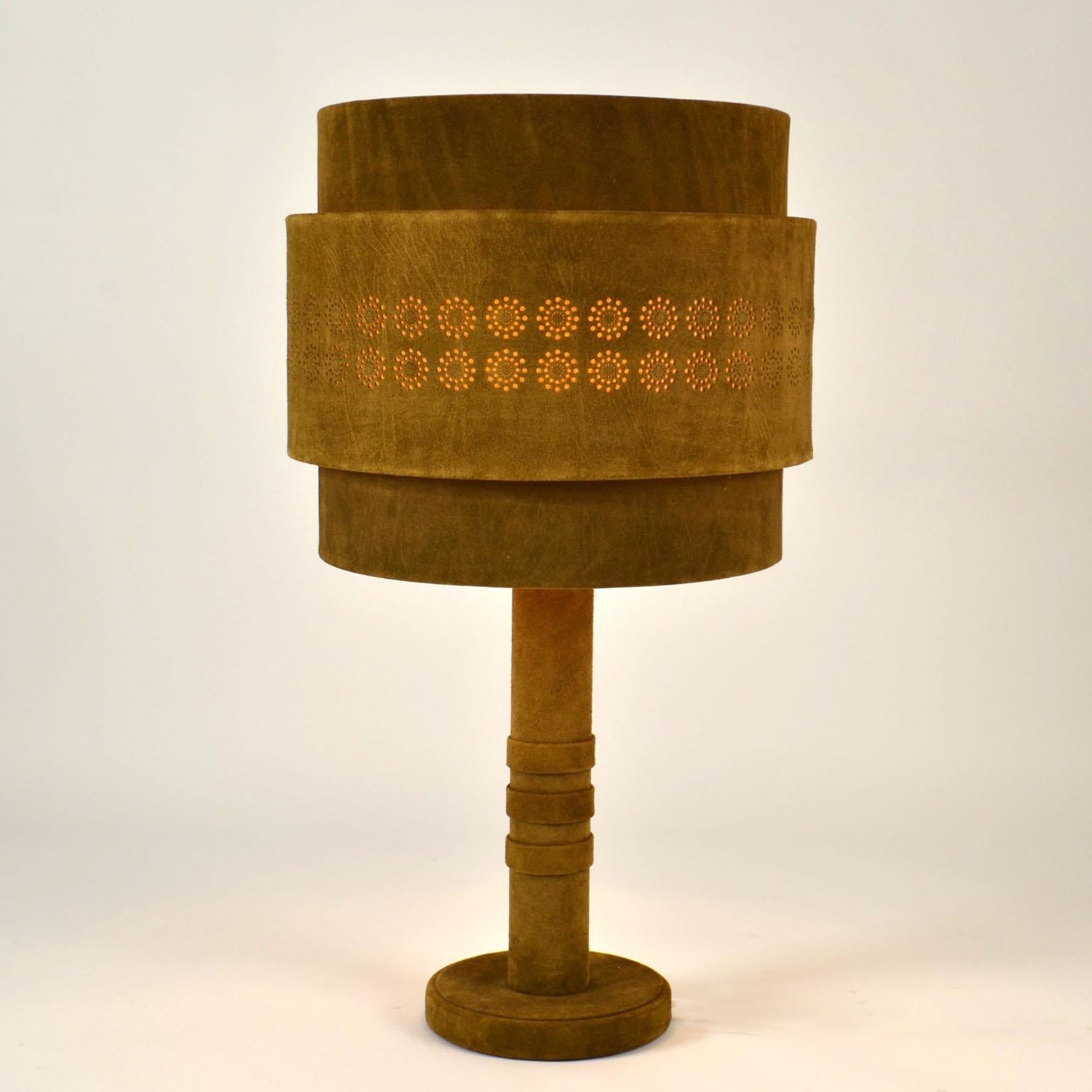 Lampe de table en daim vert mousse des années 1960 par Charlotte Wawer. L'abat-jour en parchemin à deux couches, fabriqué à la main, est recouvert de daim perforé de façon circulaire, créant ainsi une lumière atmosphérique chaleureuse. La base et la