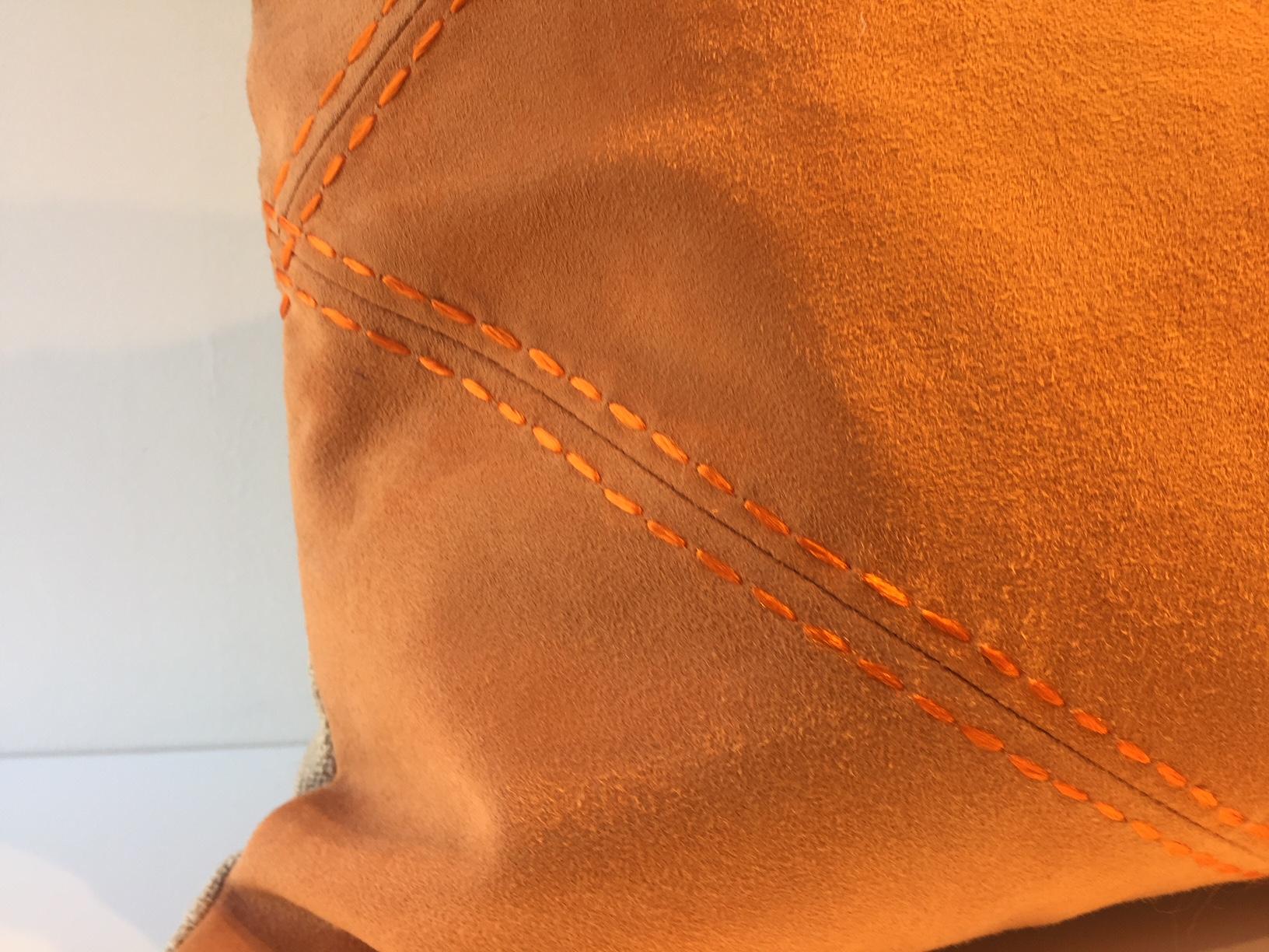 Dimensions du coussin : 35 x 50cm, panneau avant en cuir suédé très souple couleur Mandarine avec détail losange souligné par une couture sellier à la main, panneau arrière en tissu, lin tissé à la main couleur sable, housse de coussin avec doublure