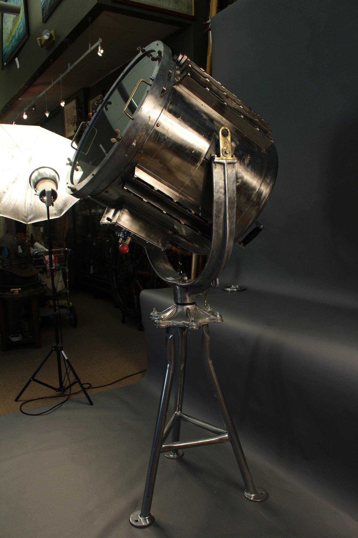 Huge six foot high aluminum spotlight with mounting yoke and fixed tripod stand. The light swivels on its base. Search light comes from a Suez Canal supertanker.

Overall dimensions: 27 1/12” bezel diameter x 30” deep x 82” H.
 