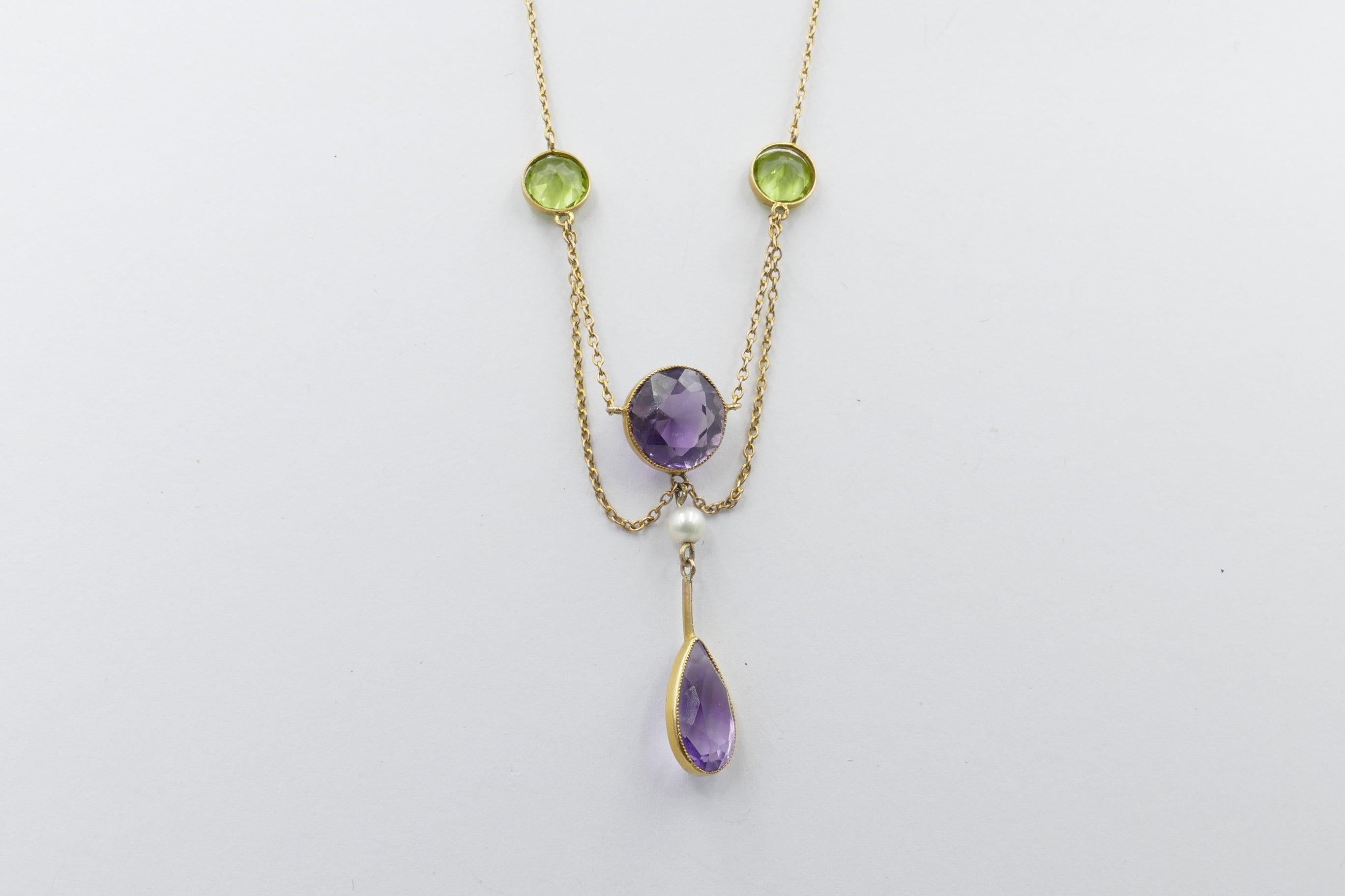 The traditional Colours of the Suffragette Movement, Purple, Green & White are shown to advantage in this genuine (and very hard to source) Suffragette Necklace.
The Amethyst are a strong purple, eye-clean, Round and Pear Cut, Bezel Set. 2 Peridots