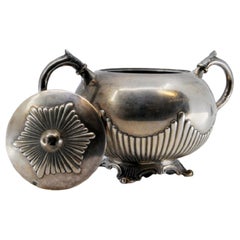 Sugar bowl in fluted silver w/ acanthus leaf handles
resting on 4 raised feet