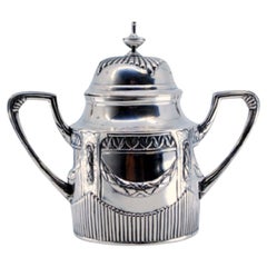 Sugar bowl in fluted silver with reliefs and scrolls, lid with knob