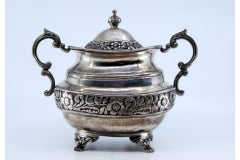 Sugar bowl in silver with a revealed surround and lid, resting on four claw feet