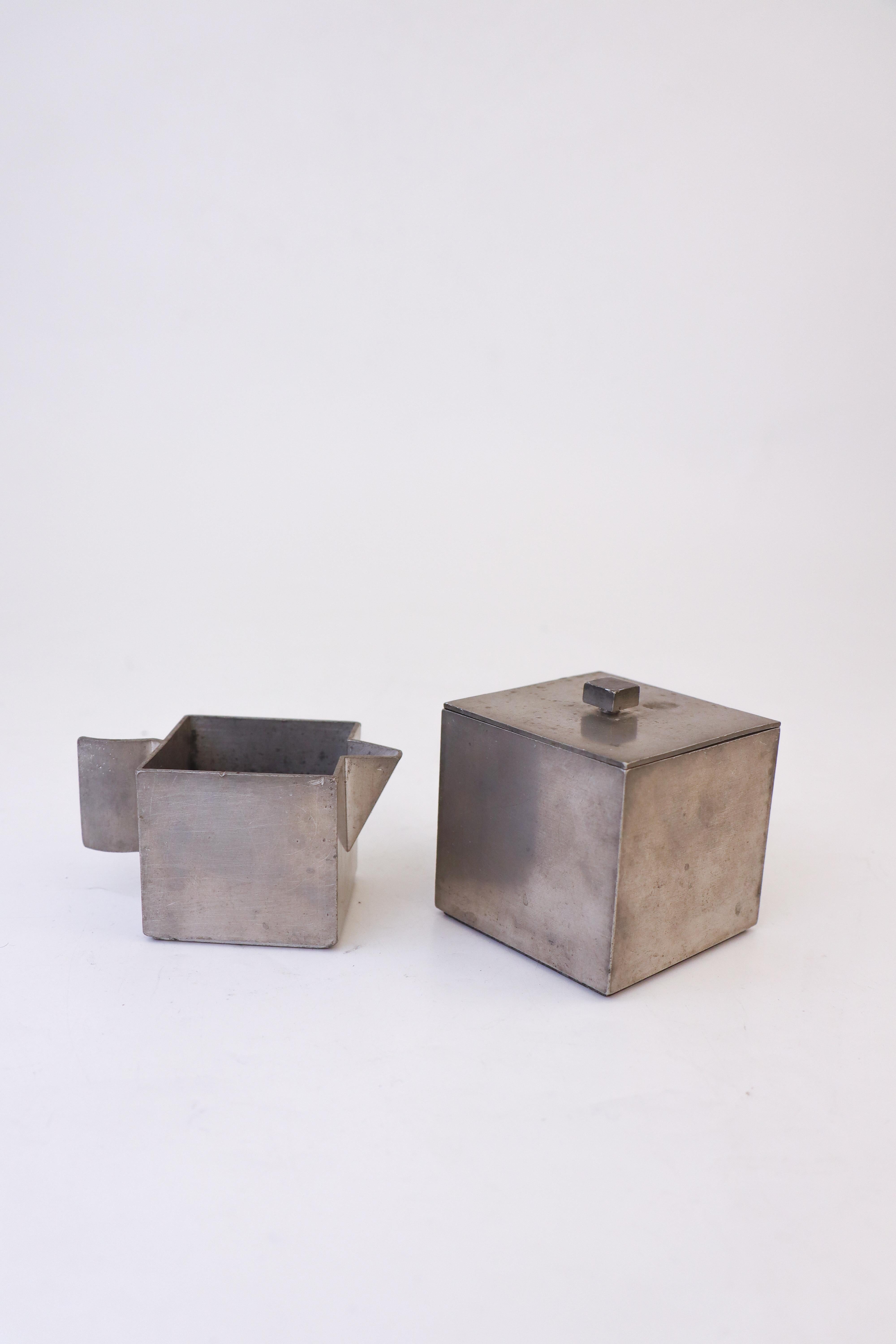 A really rare sugar bowl and creamer in pewter designed by Björn Trädgårdh at Svenskt Tenn in Stockholm in 1930. The sugar bowl is 7,5 cm tall and the creamer 5.5. cm tall. They are both in excellent condition except from some minor scratches and