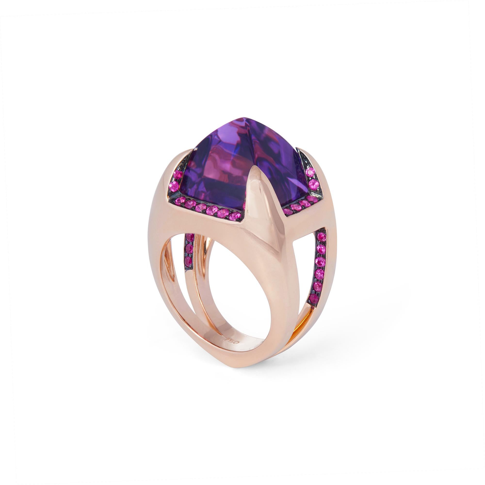 A striking cocktail ring crafted in 18 karat rose gold and set with a sugarloaf cabochon amethyst framed by pink sapphires.  US size 6 1/2.  Stamped 750, RHR.  CIRCA 2010s

Metal: 18k Rose Gold
Gemstone: Amethyst, Pink sapphire
Condition: