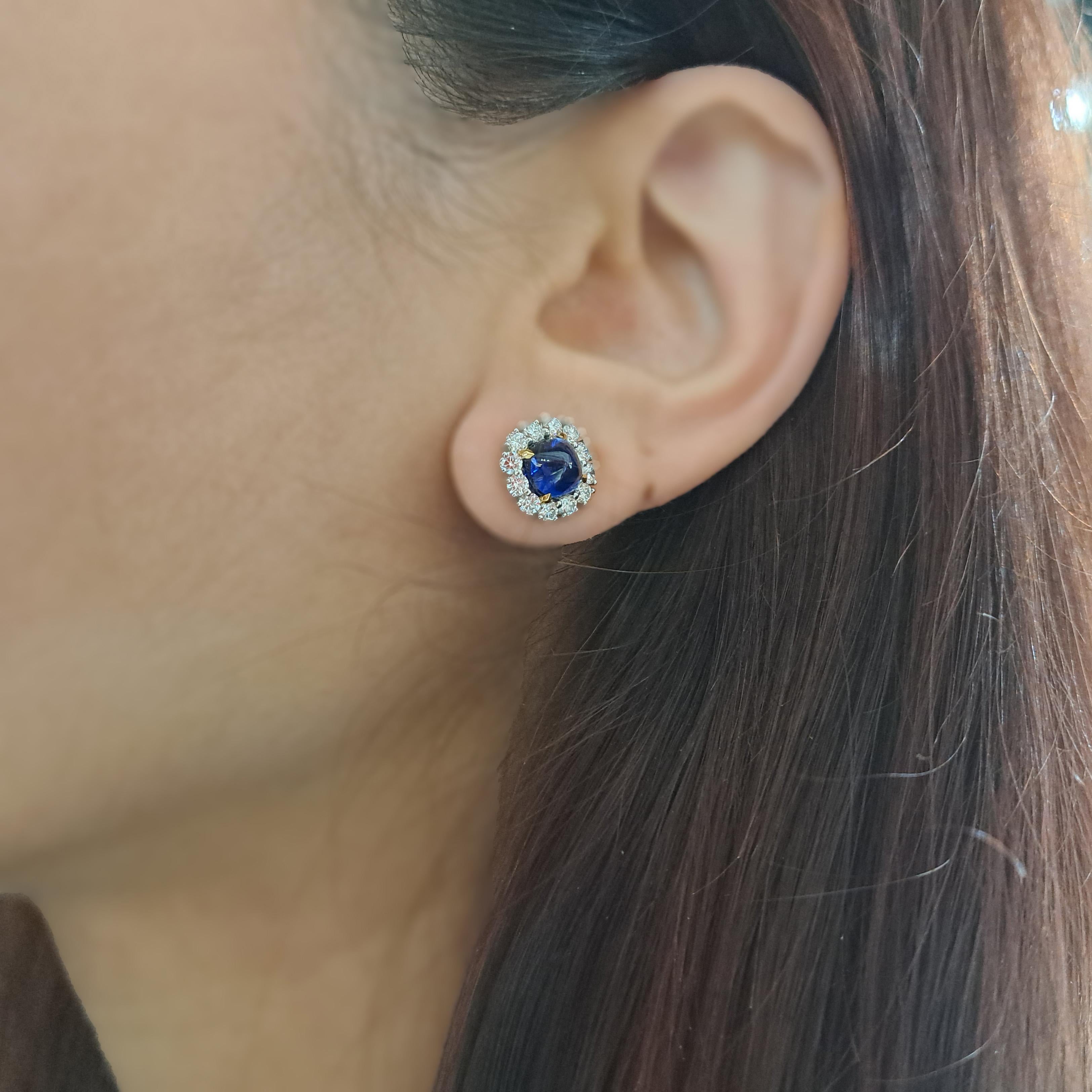 Un paio di moderni orecchini a grappolo con zaffiri e diamanti, incastonati con una coppia di zaffiri taglio sugarloaf cabochon, per un peso totale di 2,83 ct, ciascuno con un grappolo circostante di dodici diamanti rotondi taglio brillante, per un