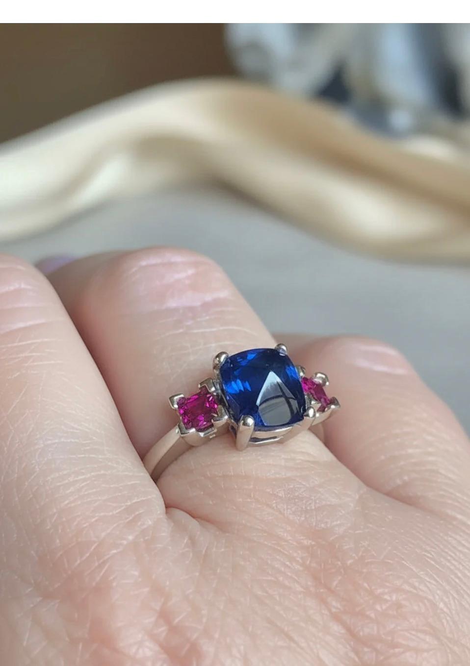 Lo zaffiro cabochon a forma di palla di zucchero pesa 3,88 carati, mentre il lato è incorniciato da due splendidi rubini naturali di colore e purezza del peso di circa 1,00 carati. Il classico anello con tre pietre è elegante e sofisticato. 
La