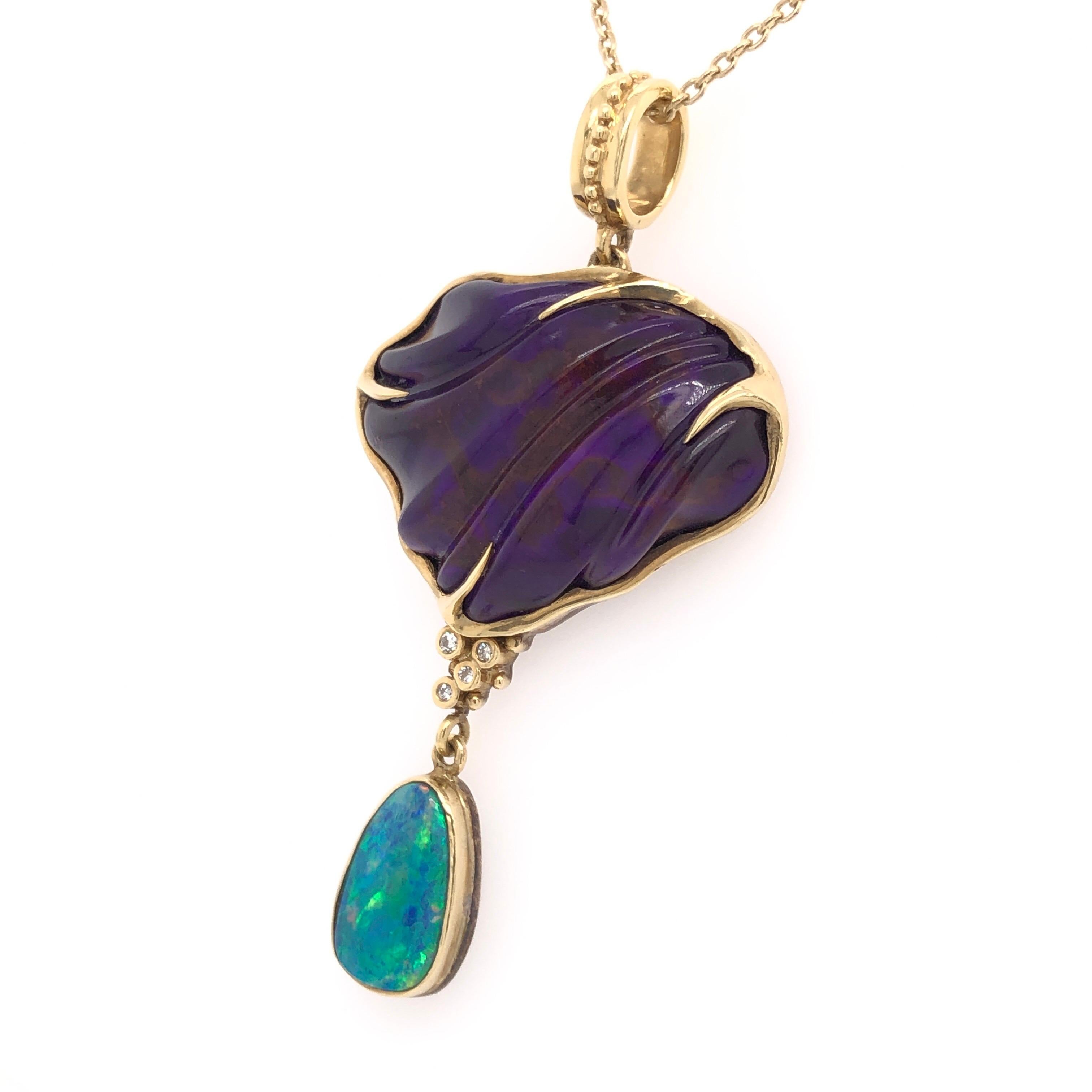 The organic form and deep color of this 28.29 CT sugilite is only enhanced by the four diamonds and pear shaped opal that dangle from it. All is set into a sterling silver setting that has been flashed with 18K yellow gold. 

Sugilite was first