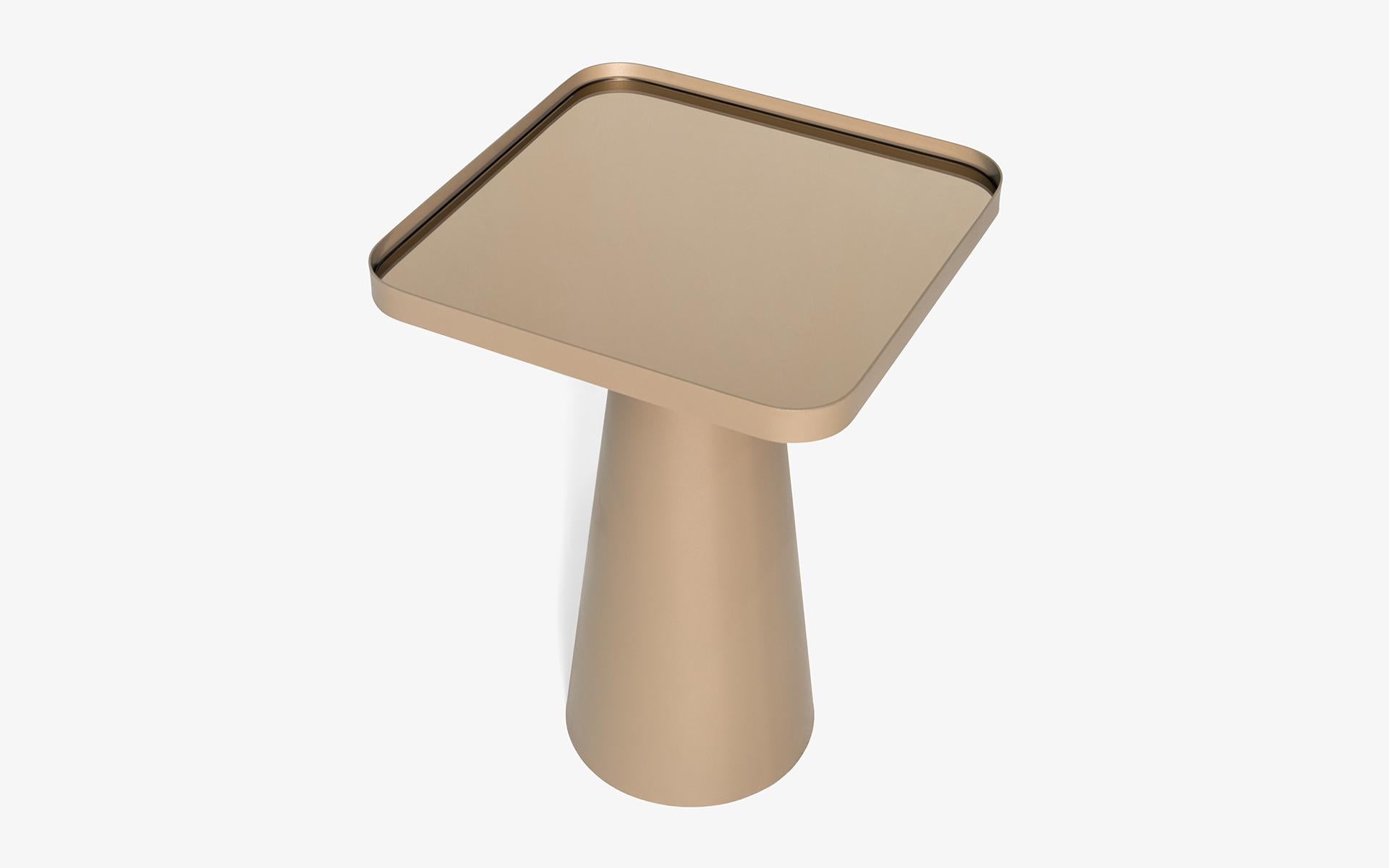 La table d'appoint Sui apporte une touche sophistiquée à vos espaces de vie grâce à son design élégant et moderne. Tandis que son pied conique en métal affiche une position équilibrée et forte, la table miroir en bronze placée dans un cadre