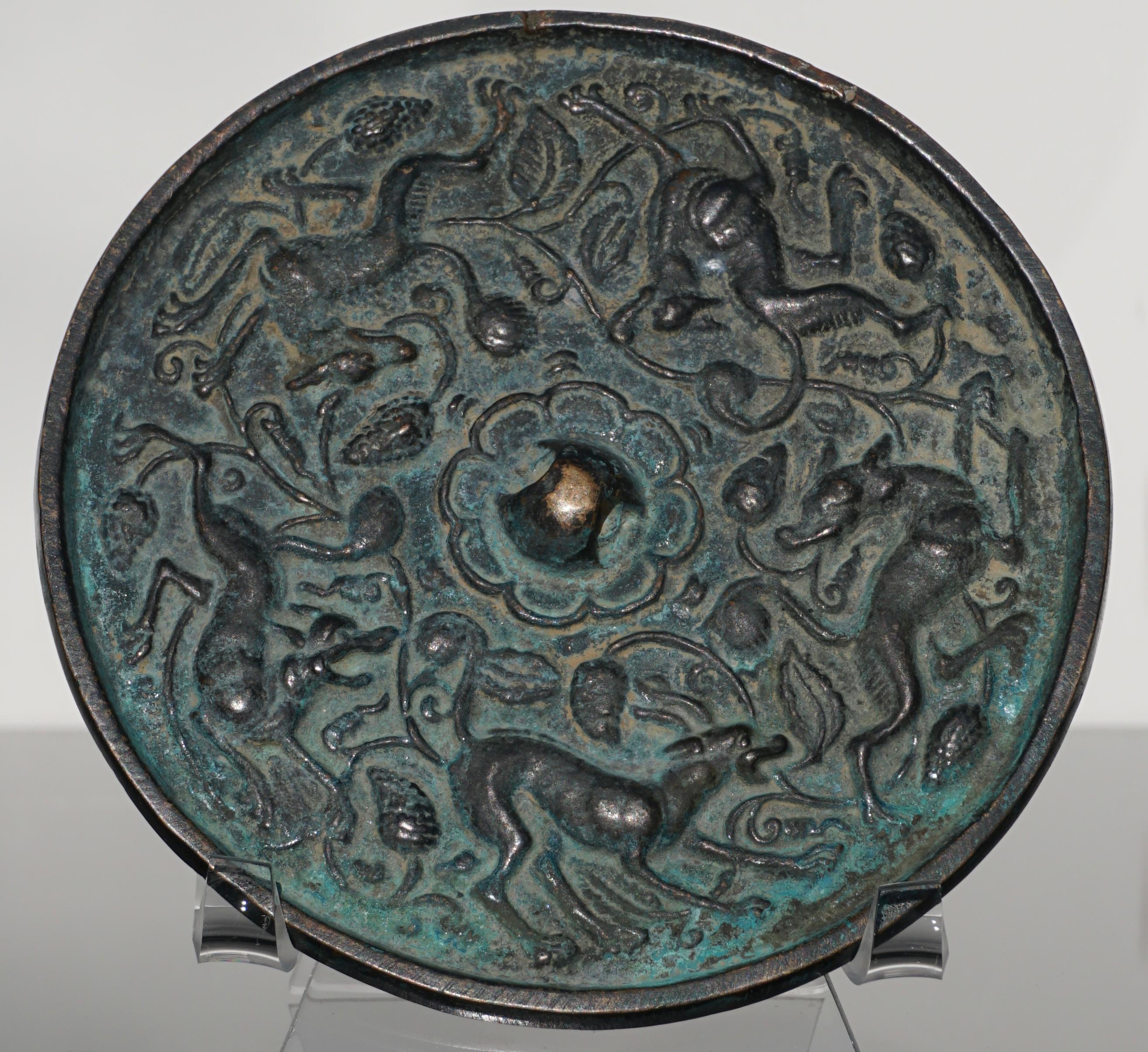 Tang dynasty, Chinese bronze mirror of 5 running suani beasts and grapevines. The pierced nub has a floral lotus in the centre. These mirrors were very prevalent in china among the elite status and had many uses from looking at ones self to