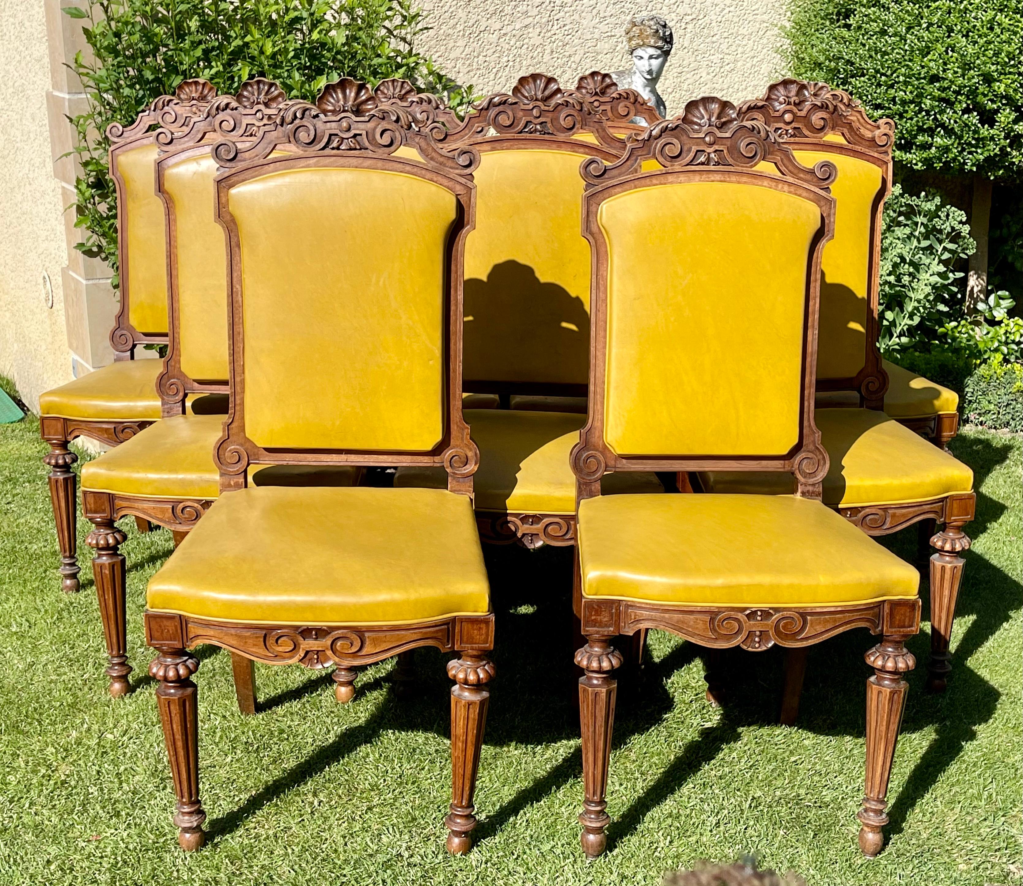 Suit of 9 carved walnut chairs Napoleon III period - XIXth. They are covered with mustard yellow imitation leather. The backrests and seats are made up of easily removable cakes. The whole is in good condition. 
To be noted - some shells on top of