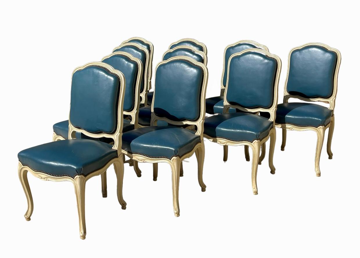 Suite of 10 large Louis XV style lacquered wood chairs. Blue leather back and seat in good condition. Circa 1930/1940.
Note: a chair with damaged leather on the seat