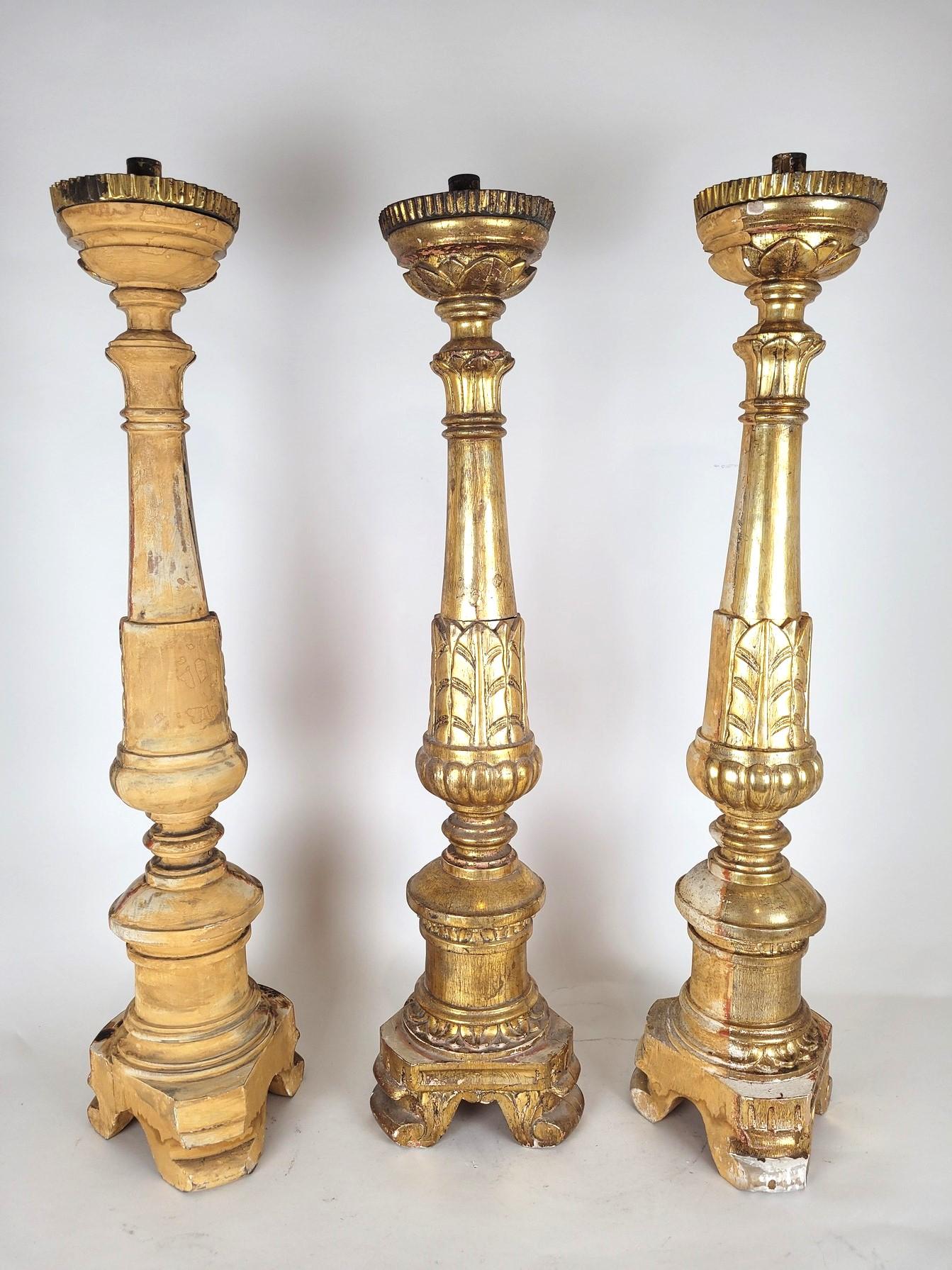 Set of 3 large Italian gilded wood candlesticks: placed against a wall, they are gilded only on the visible part, 