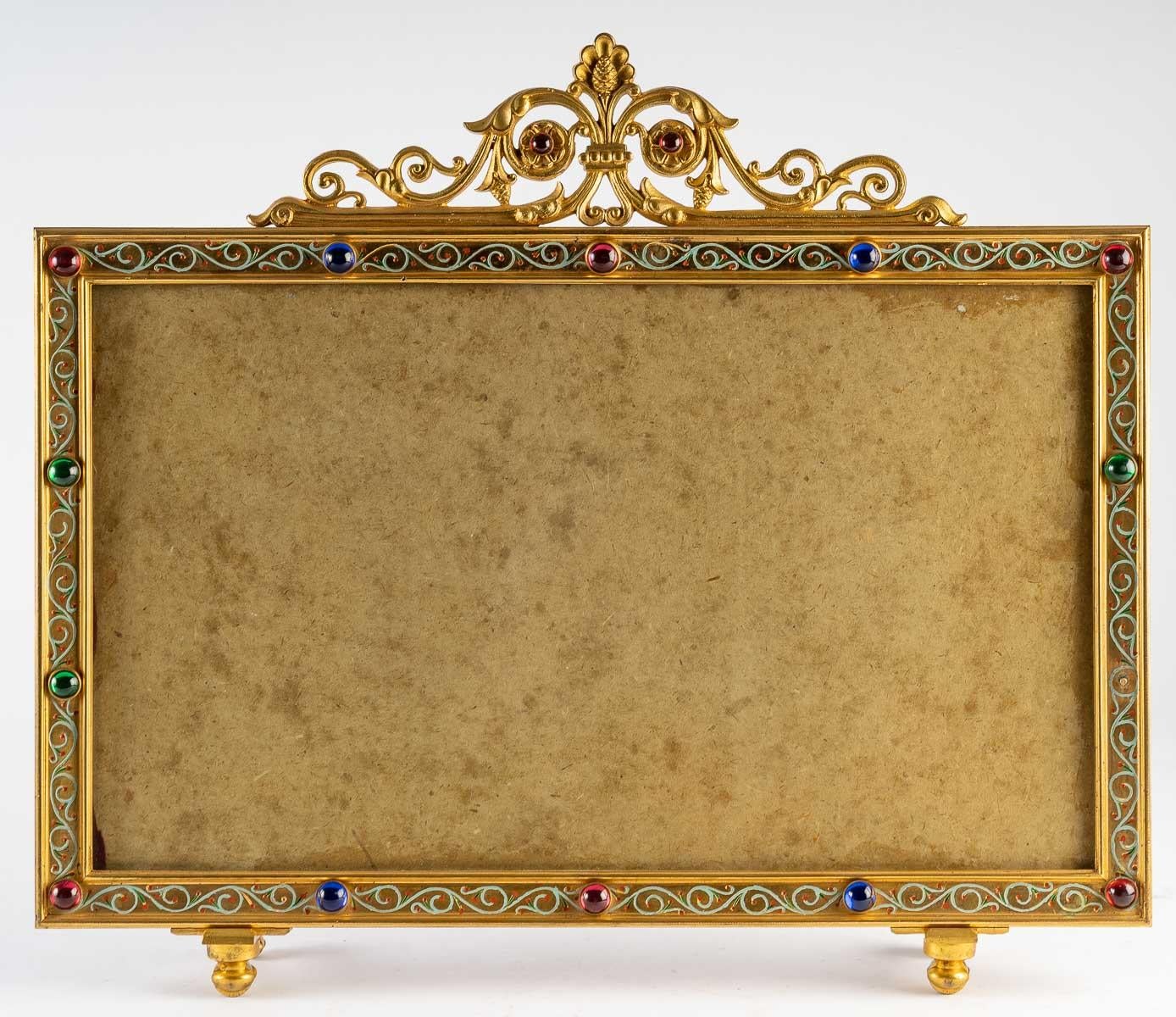 Suite of 3 Photo frames, gilt bronze with coloured glass cabochons, 19th century, Napoleon III period, on bronze castors on the base.
The pair - H: 38.5 cm, W: 21 cm, D: 8 cm;
The large one - H: 41.3 cm, W: 48 cm, L: 8 cm.