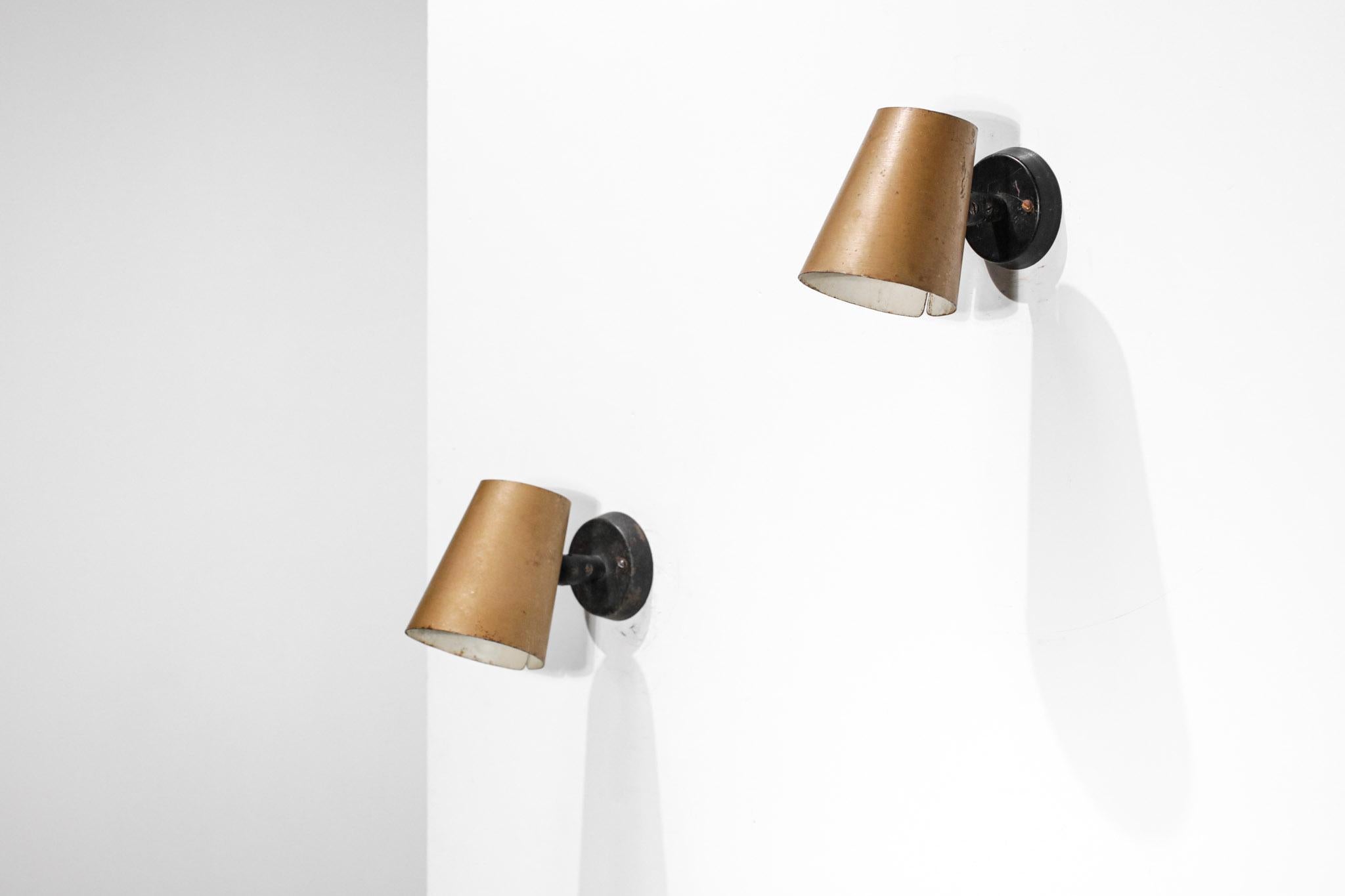 Pair of French sconces from the 50's. Shade in gilded lacquered metal (original paint), attachment system and ball joint allowing their orientation in black lacquered metal. Very nice patina of time, to note many traces of use (cf photos) as well as