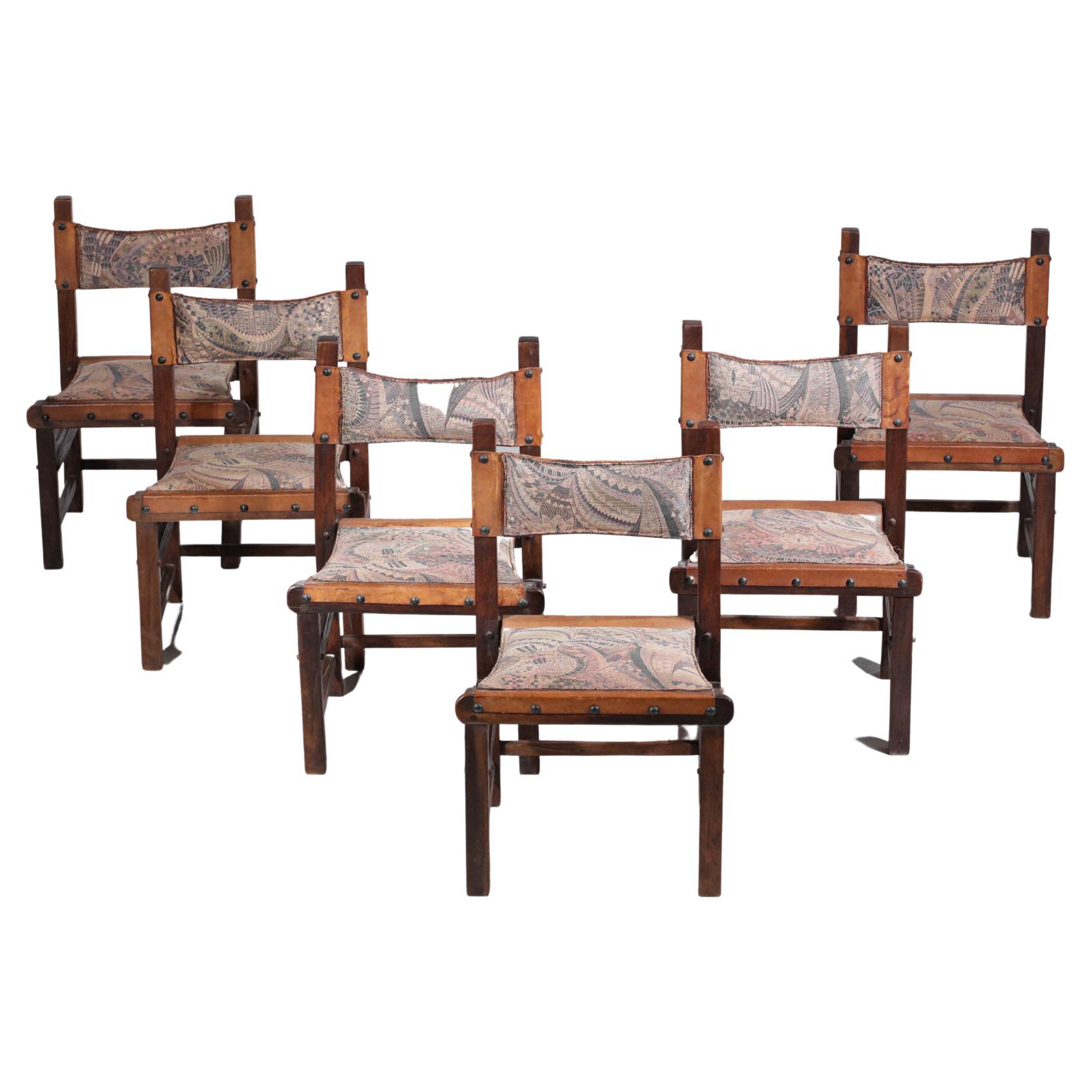 Ensemble de six chaises brésiliennes des années 60. Structure en bois massif, dossier et assise en cuir cognac recouvert d'un tissu à motifs géométriques (acheté en état, tissu déjà présent sur les assises depuis longtemps au vu des traces