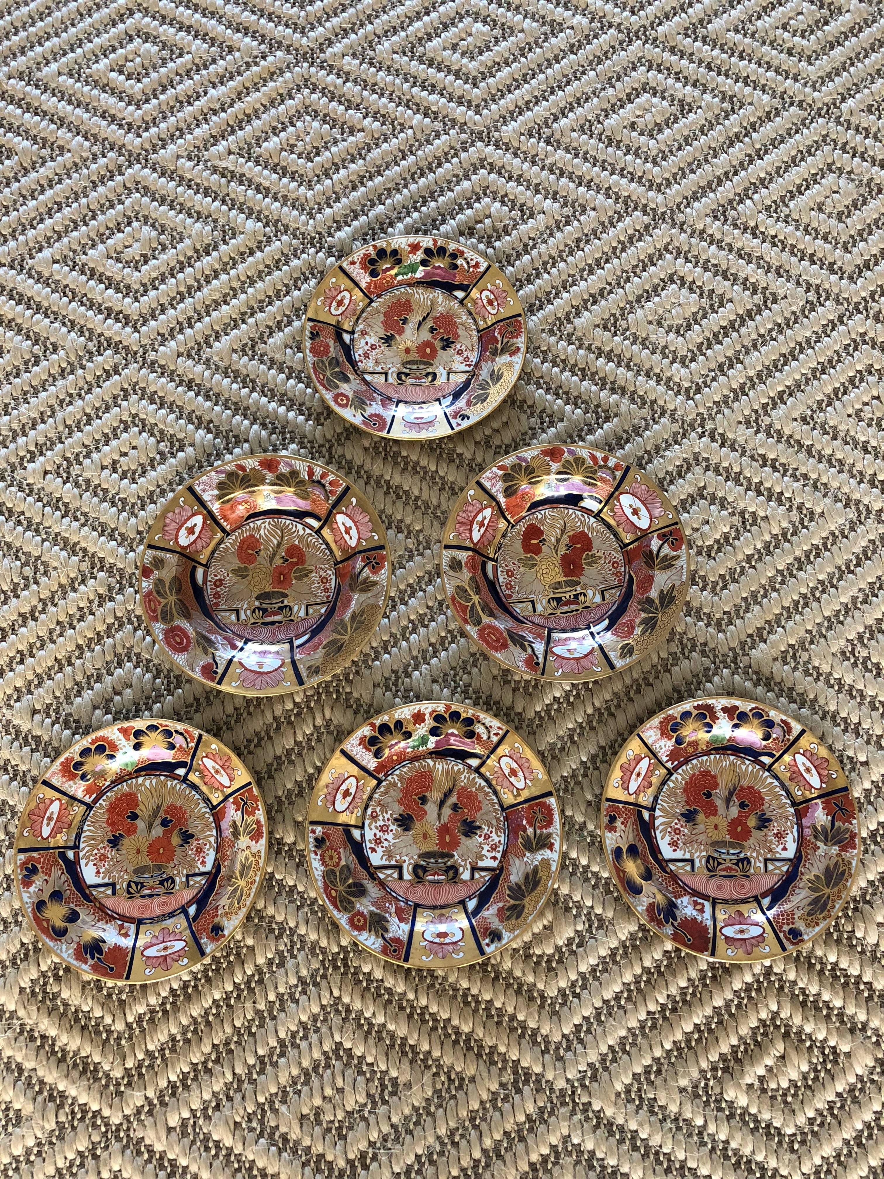 This suite is of two bowls and four plates early 19th century Chamberlain's Worcester Porcelain dishes, circa 1804, decorated in underglaze blue and having enamel red and gold in the Imari style marked in purple thinking this is early Nelson Pattern.