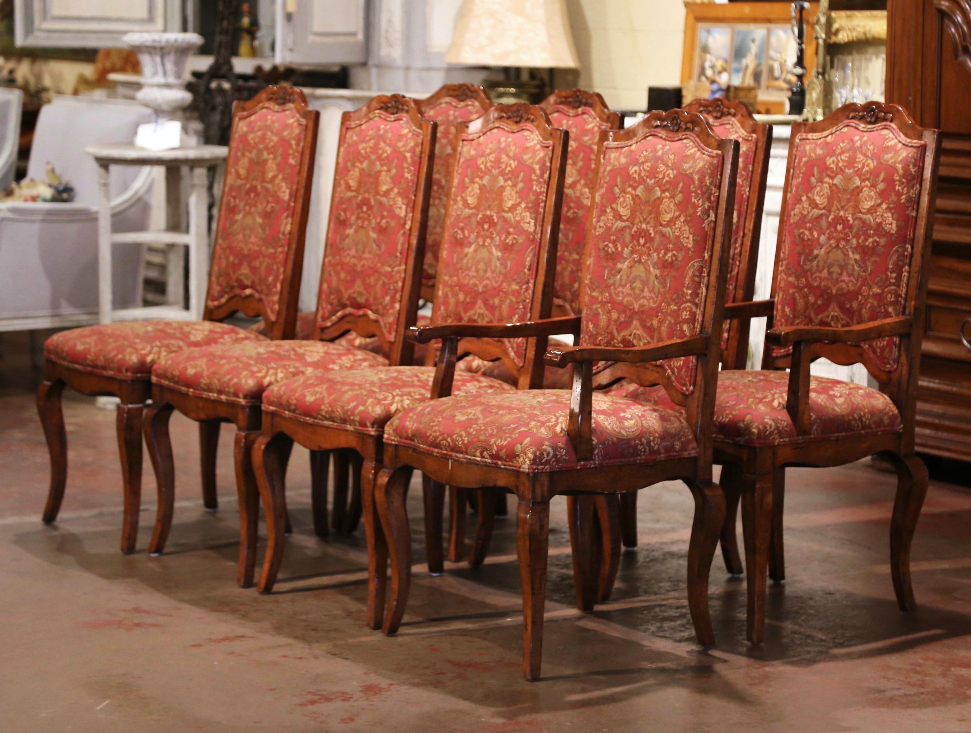 Dress a breakfast or dining table with this elegant set of six sidechairs and matching armchairs. Crafted circa 1980 from walnut wood, each chair stands on cabriole legs over a bombe scalloped apron. Each chair has a wide and deep seat, a tall